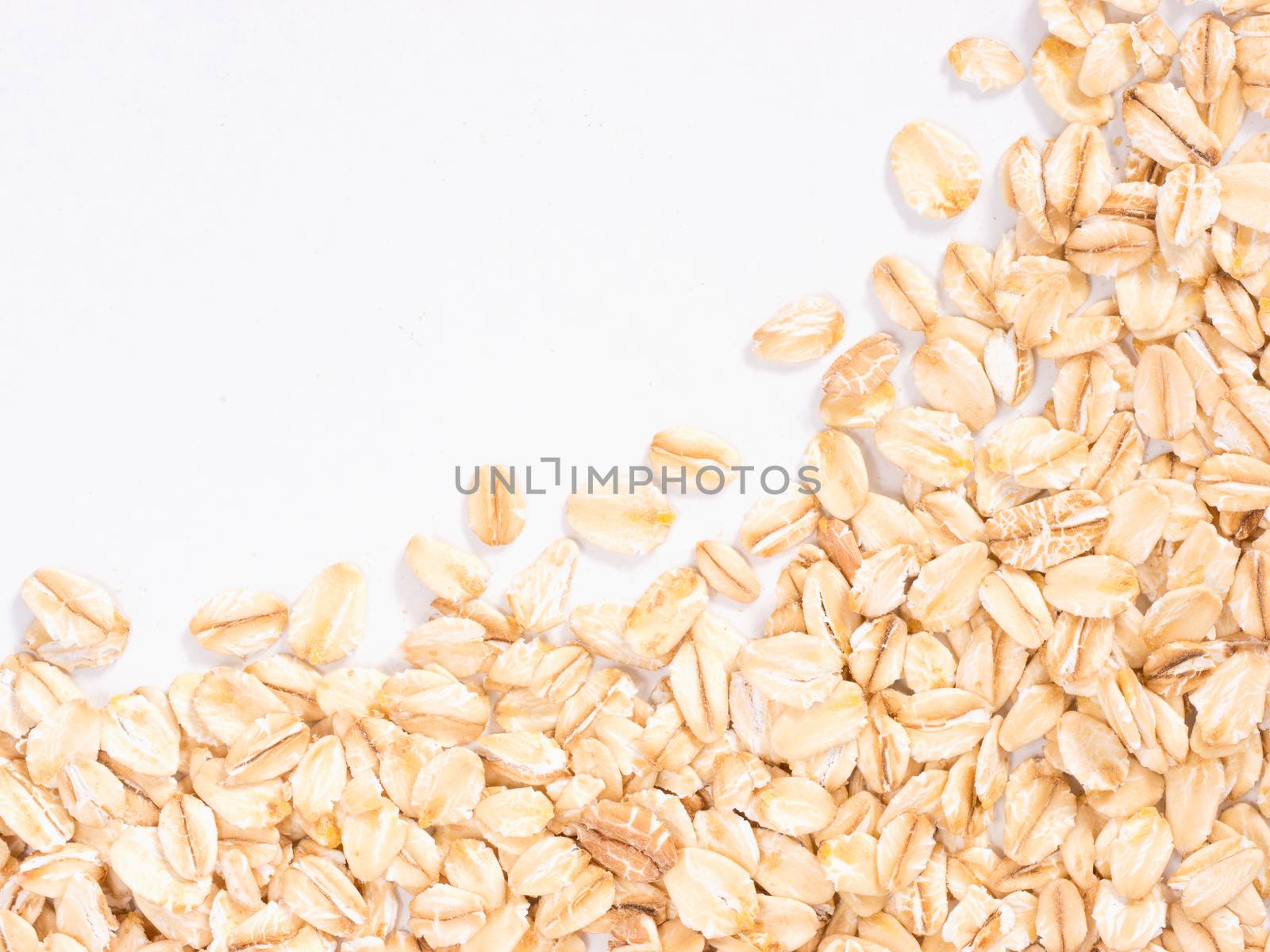 raw oatmeal on white background with copy space. Isolated one edge. Top view or flat lay.