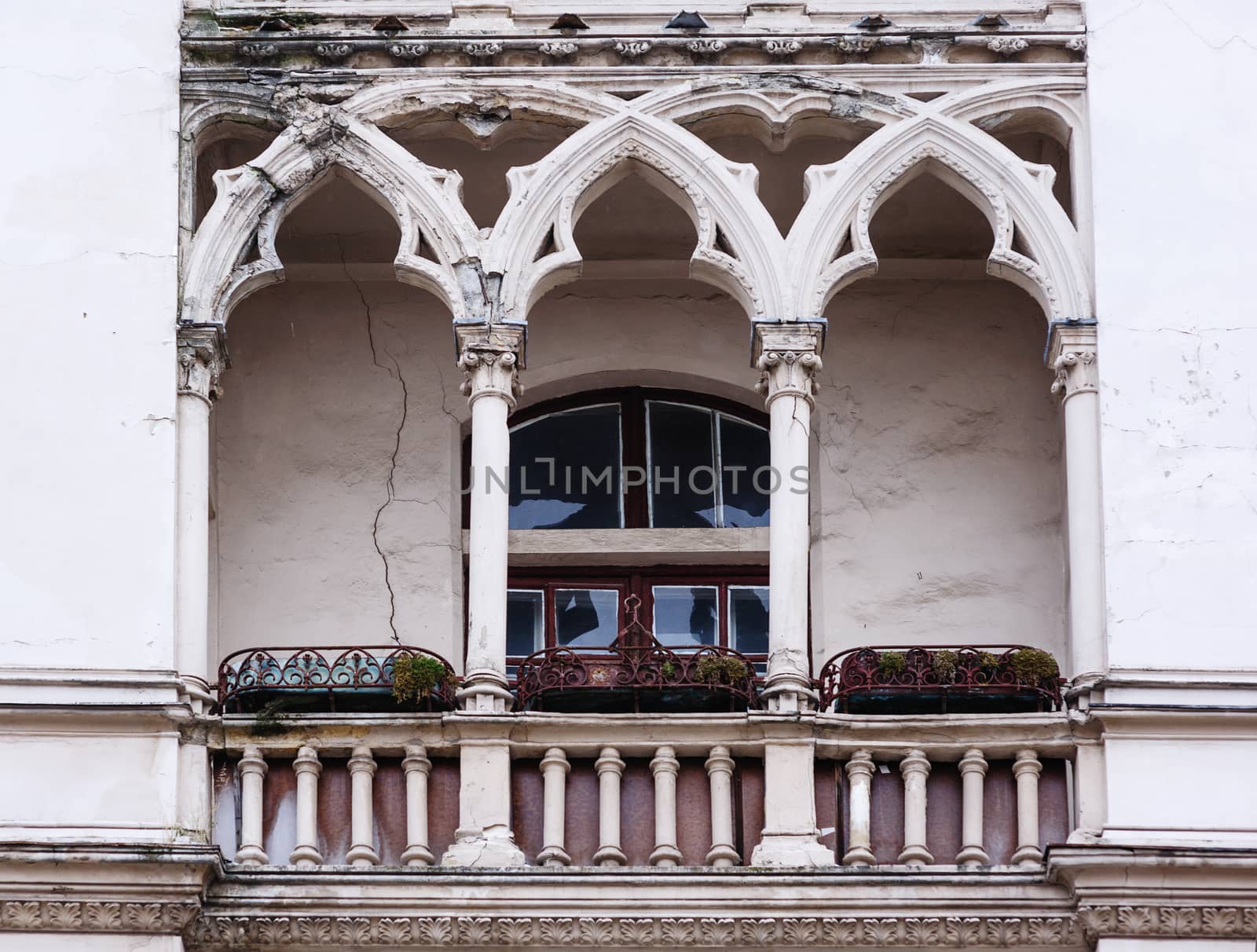 Antique balcony in the Gothic style on a building facade.