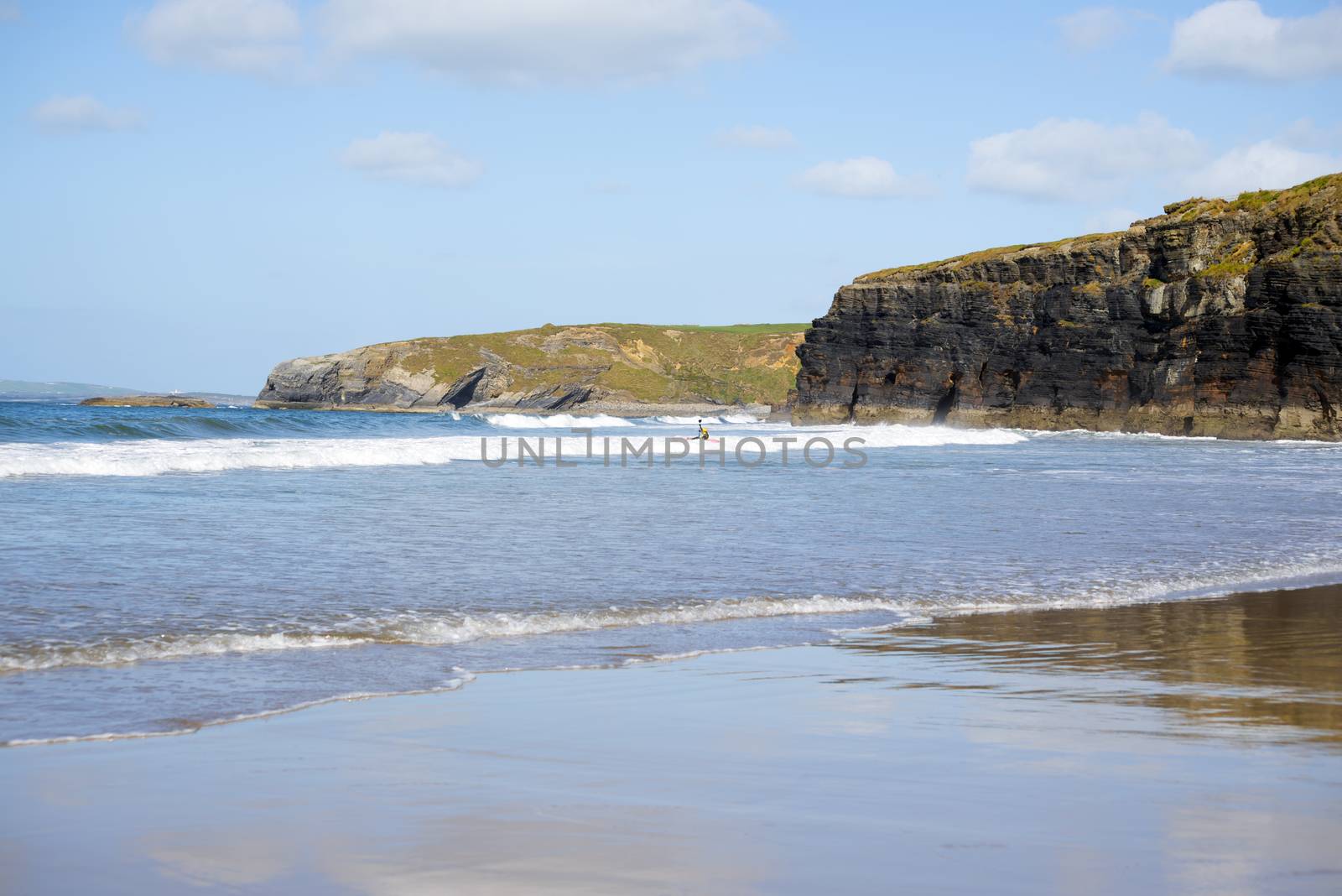 bright winter view of kayaker at ballybunion beach and cliffs on the wild atlantic way in ireland