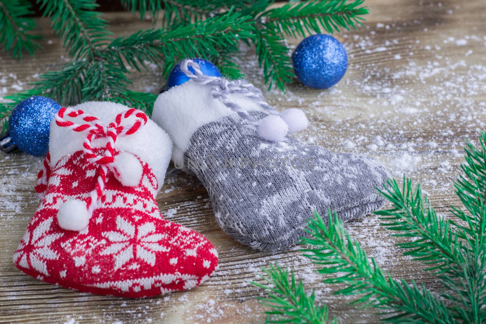 Christmas and New Year winter holiday snowbound composition of stockings on wooden space background with green fir tree branches and balls ornament