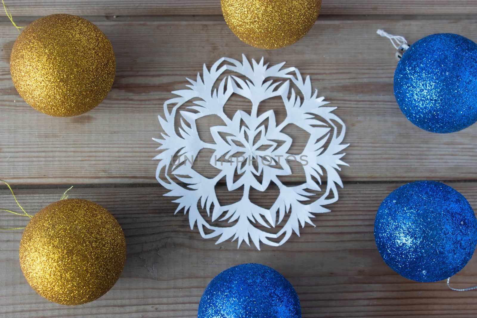 paper snowflake and Christmas balls on the wooden table