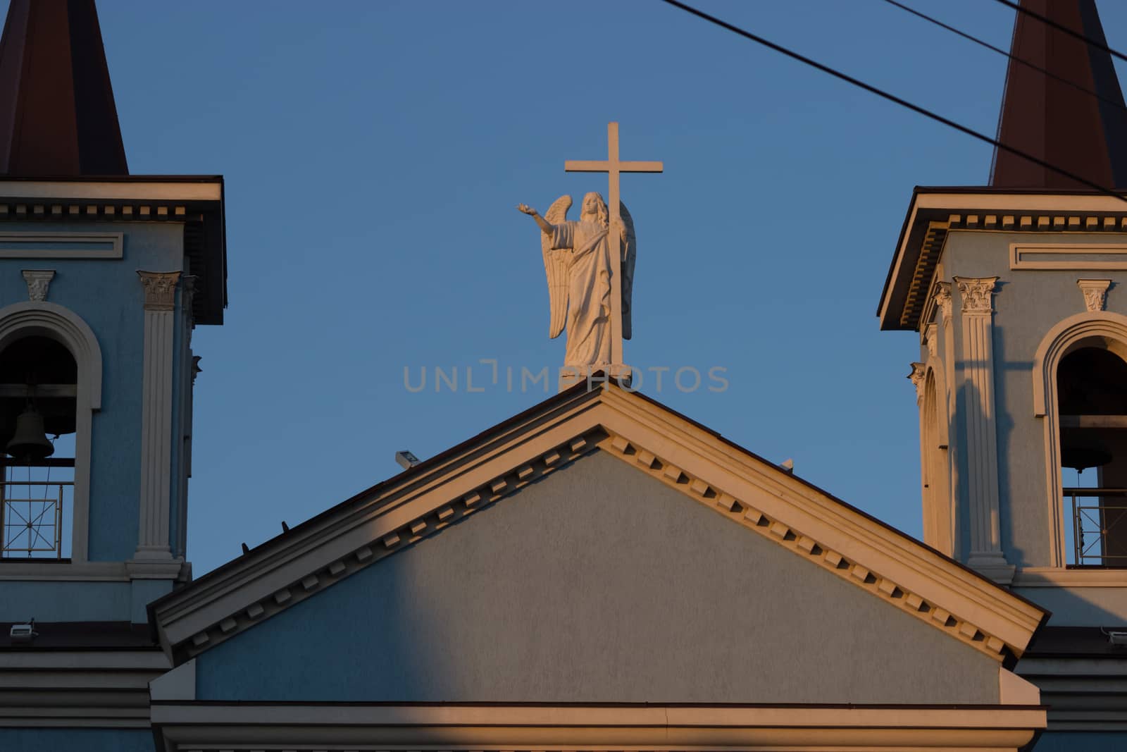 roof of a blue catholic church with angel statue