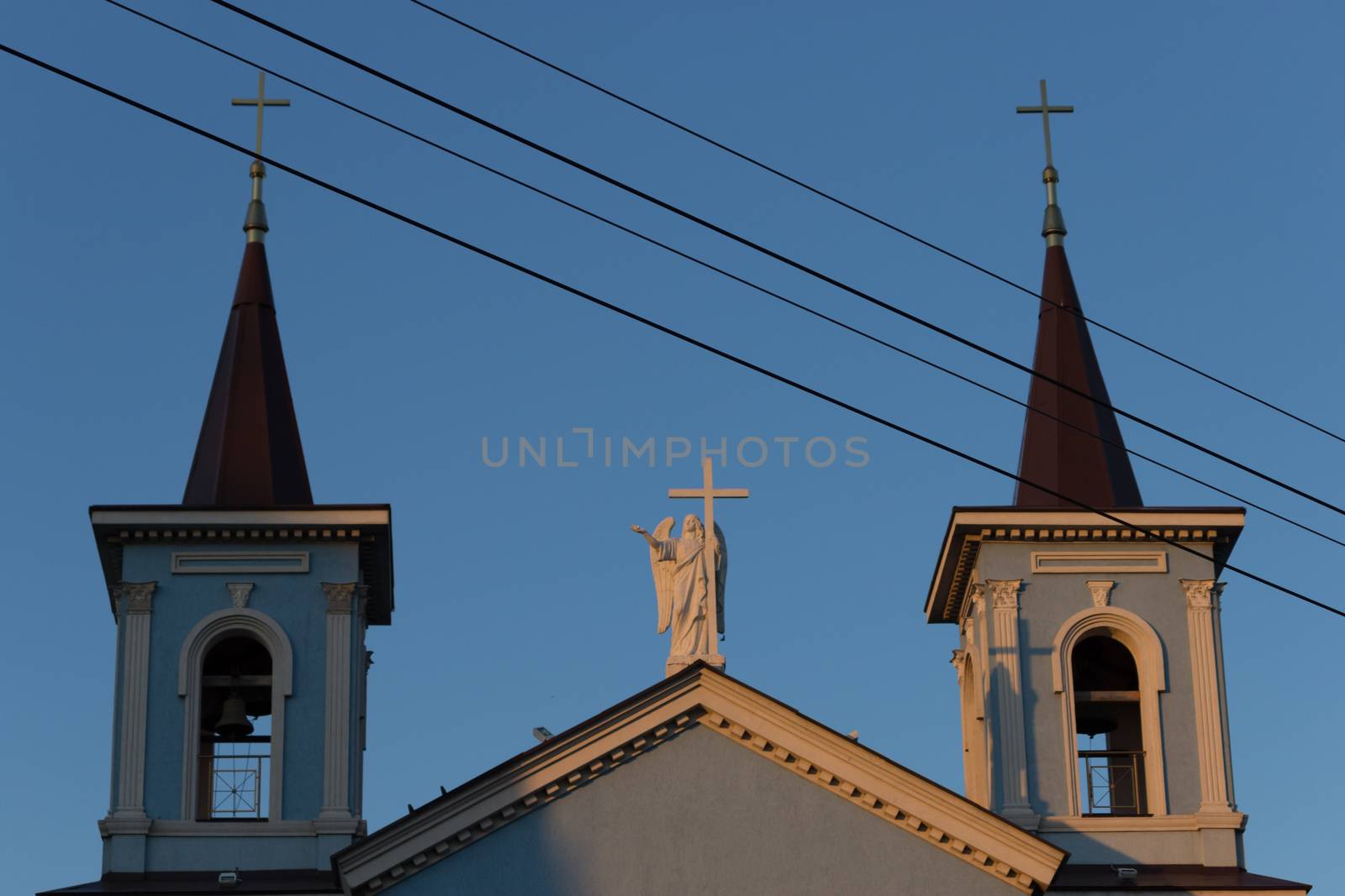 roof of a blue catholic church with angel statue