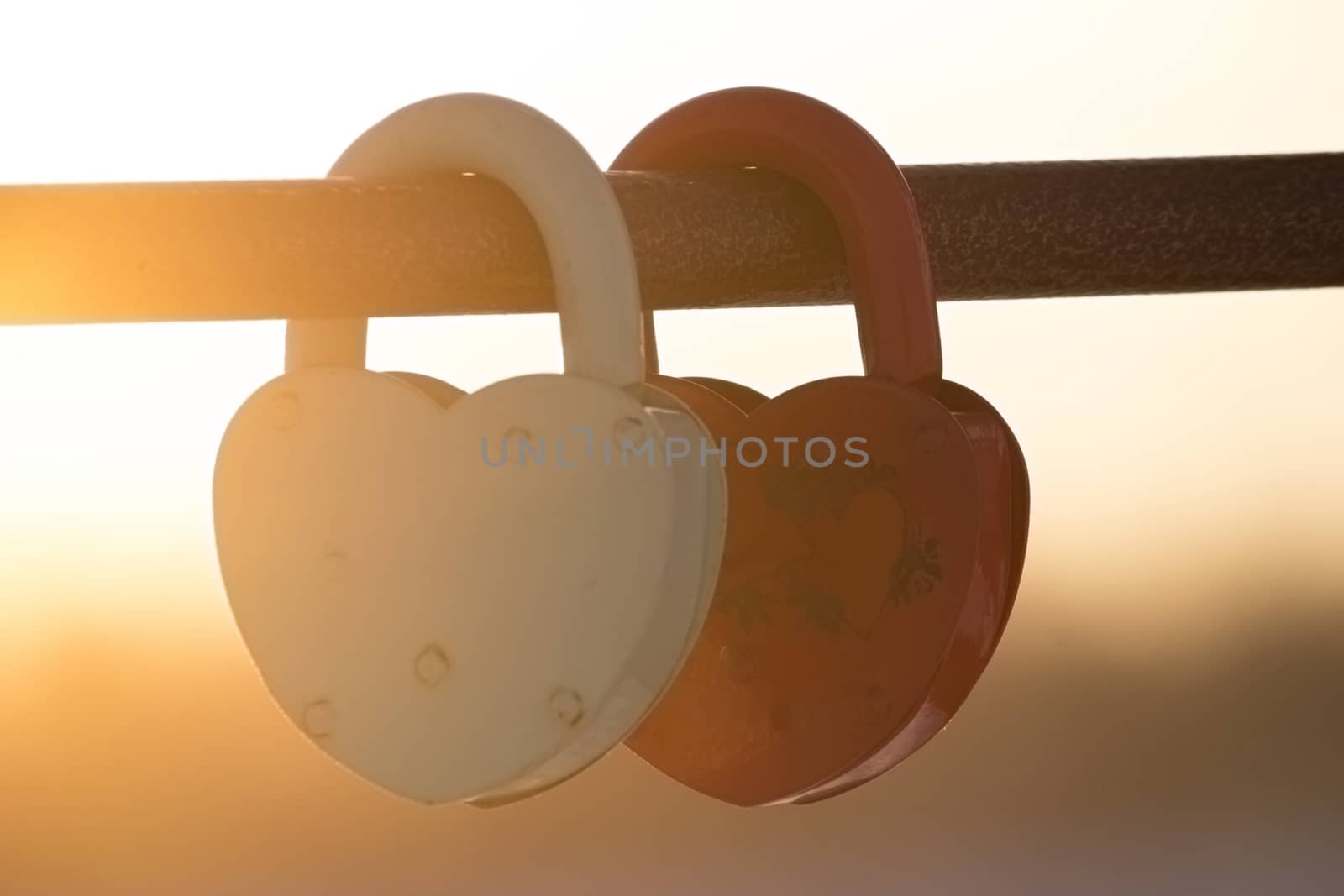 two heart shaped padlocks, beautiful sunset sunbeans