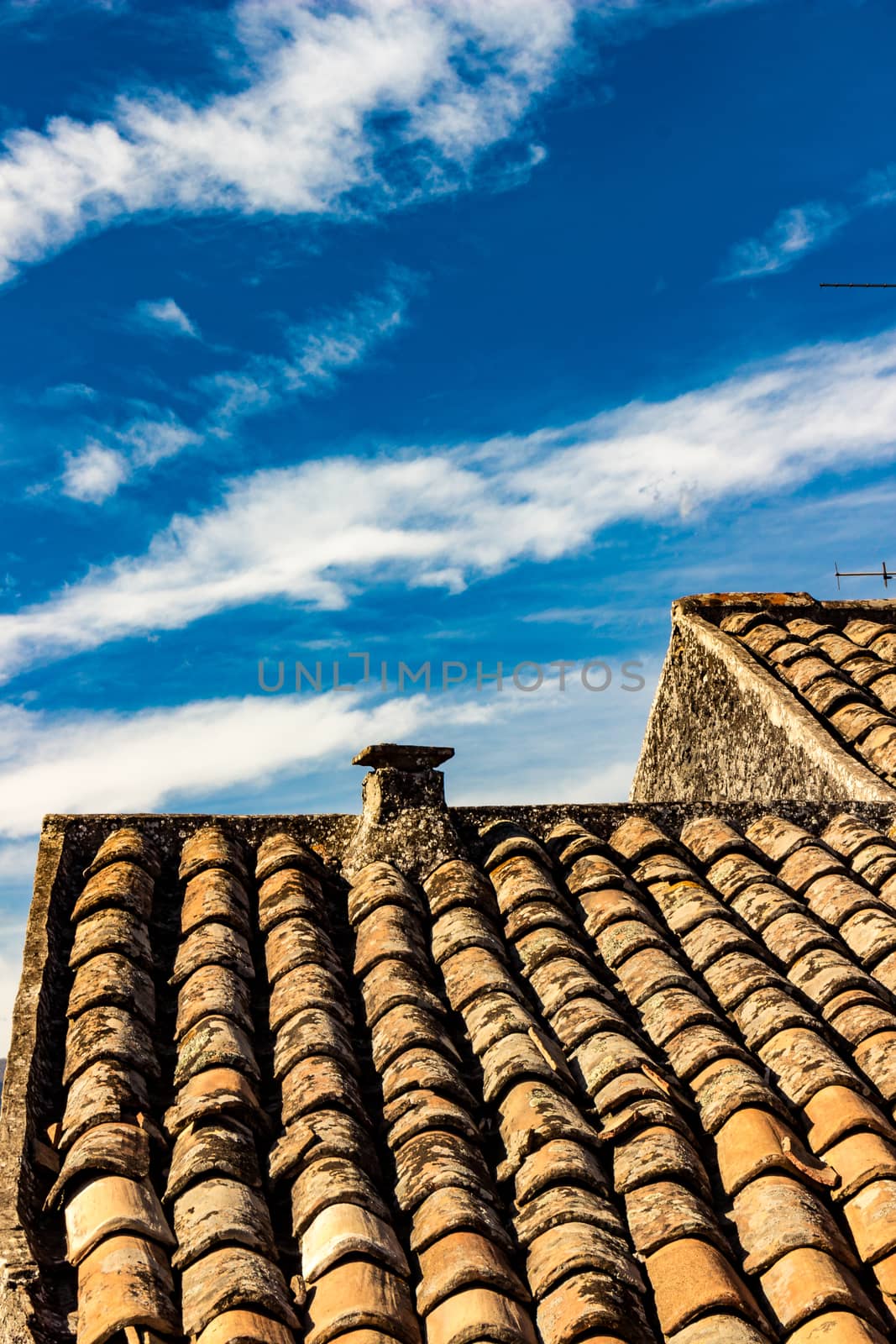 The ancient roof on a blue sky with clouds streaked