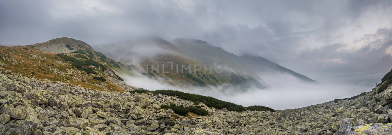 Mountains Landscape with Fog in Ziarska Valley. Rocks in Foreground.