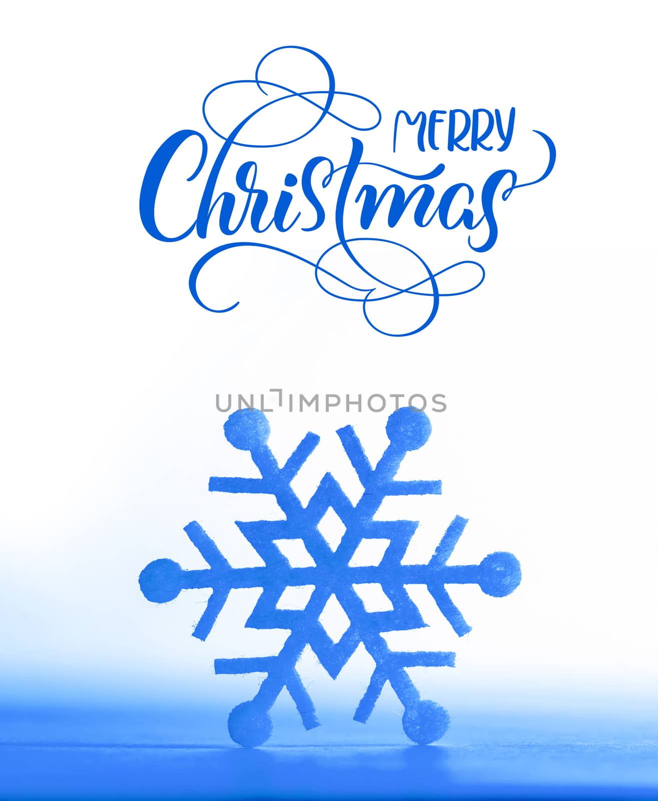 Christmas decoration. Beautiful snowflake on real snow outdoors with text Merry Christmas. Lettering calligraphy.