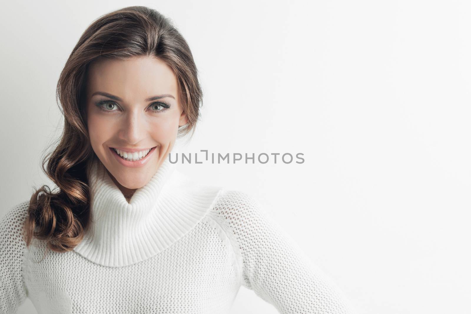 Studio portrait of beautiful long-haired woman in hot sweater on white background