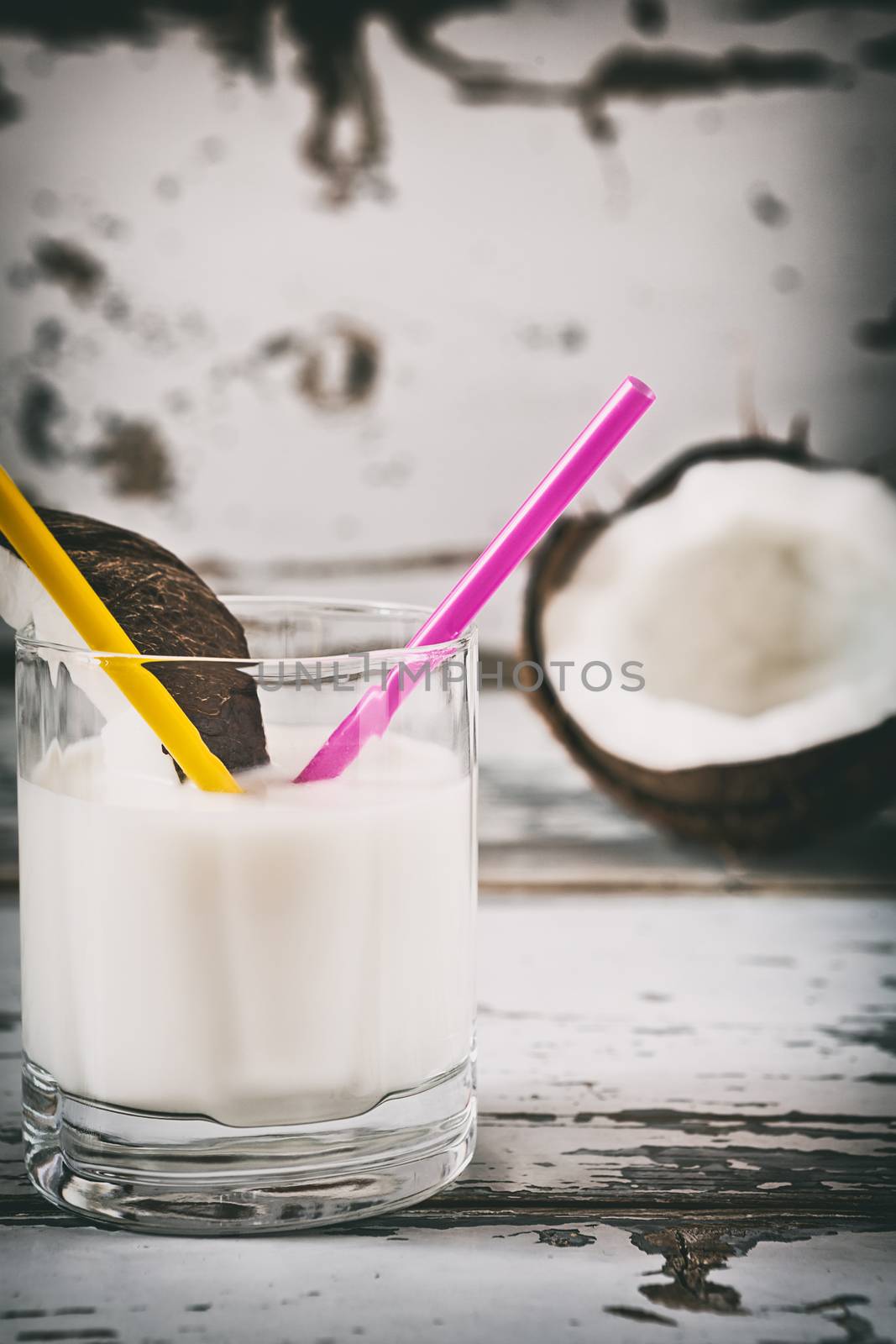 Closeup of coconut milk on a glass over a wooden background