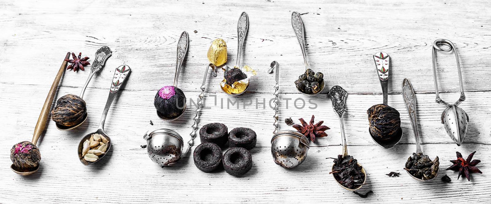 Varieties of tea leaves in a stylish tea boxes on a light wooden background