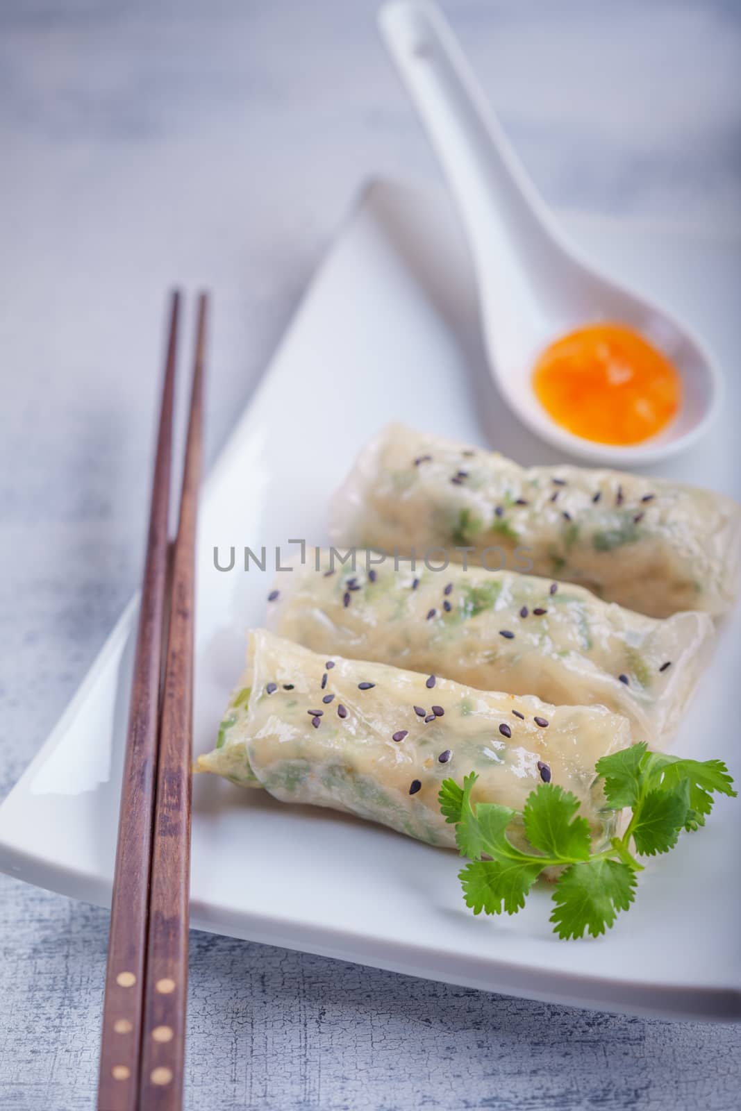 Spring Rolls with Sauce on a wooden surface.