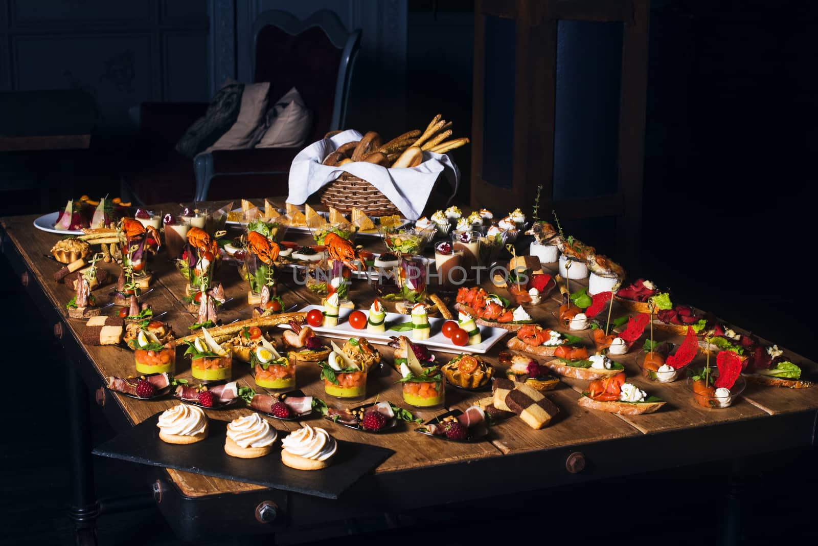 Snacks set. Brushettas, canapes, salads, desserts, tartlets, oysters on wooden table 