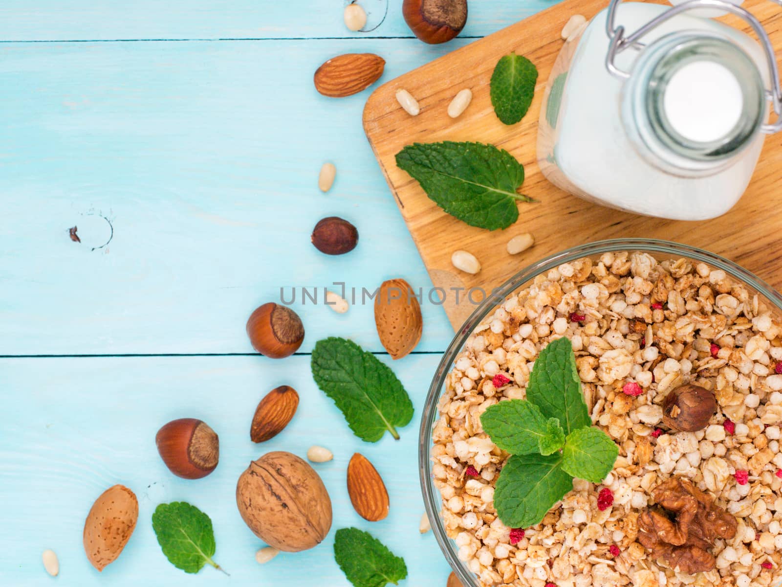 Colorful health breakfast concept. Muesli, milk and nuts on blue wooden background. Top view or flat lay. Copy space