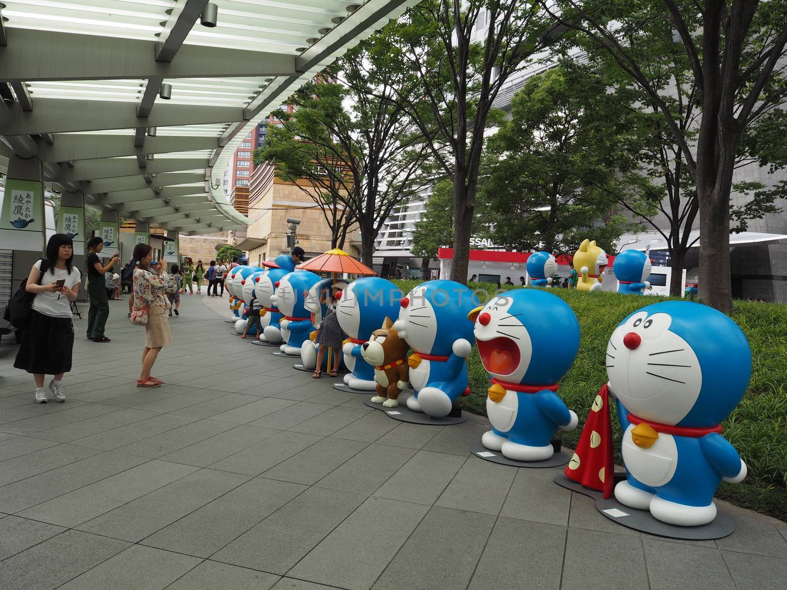 Tokyo, Japan - July 18, 2016: People are visiting the Doraemon model exhibition held at Roppongi neighborhood, Tokyo. Some people are taking their family member the photography with the curved line of the Doraemon models.