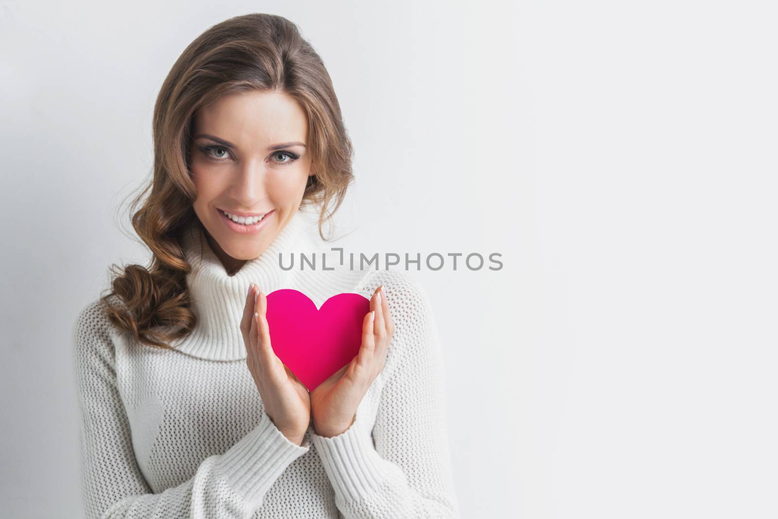 Beautiful woman holding Valentines day paper heart card