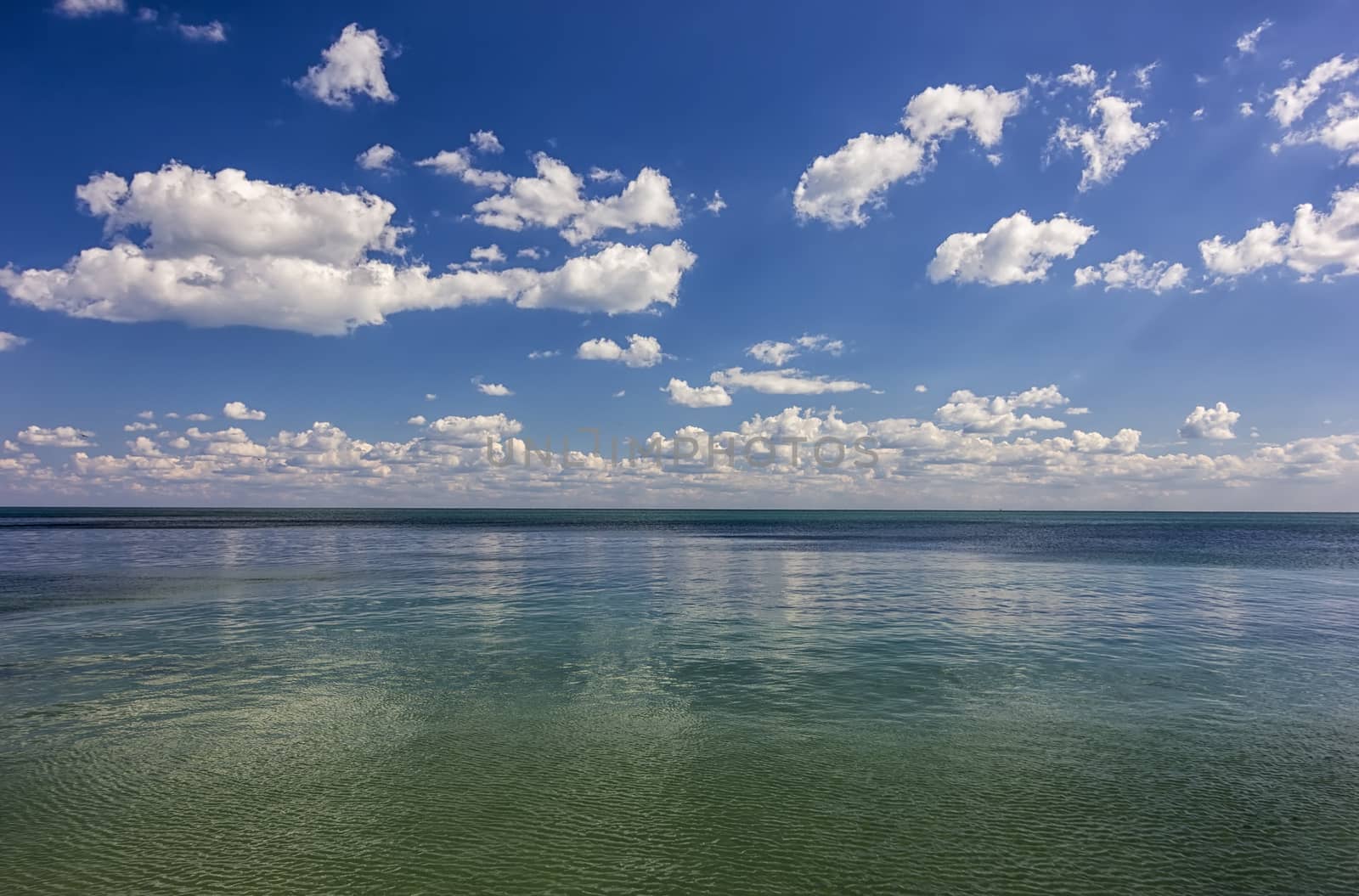 Amazing day calm sea view with clouds reflection