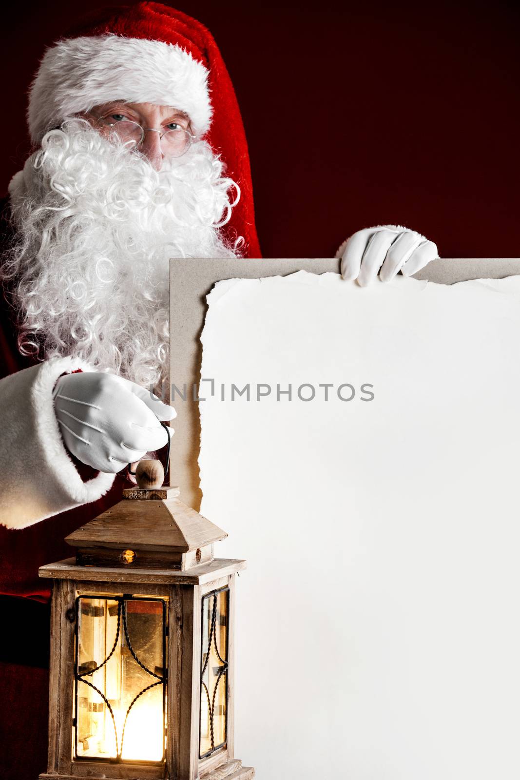 Santa Claus with vintage glowing lantern and big blank card