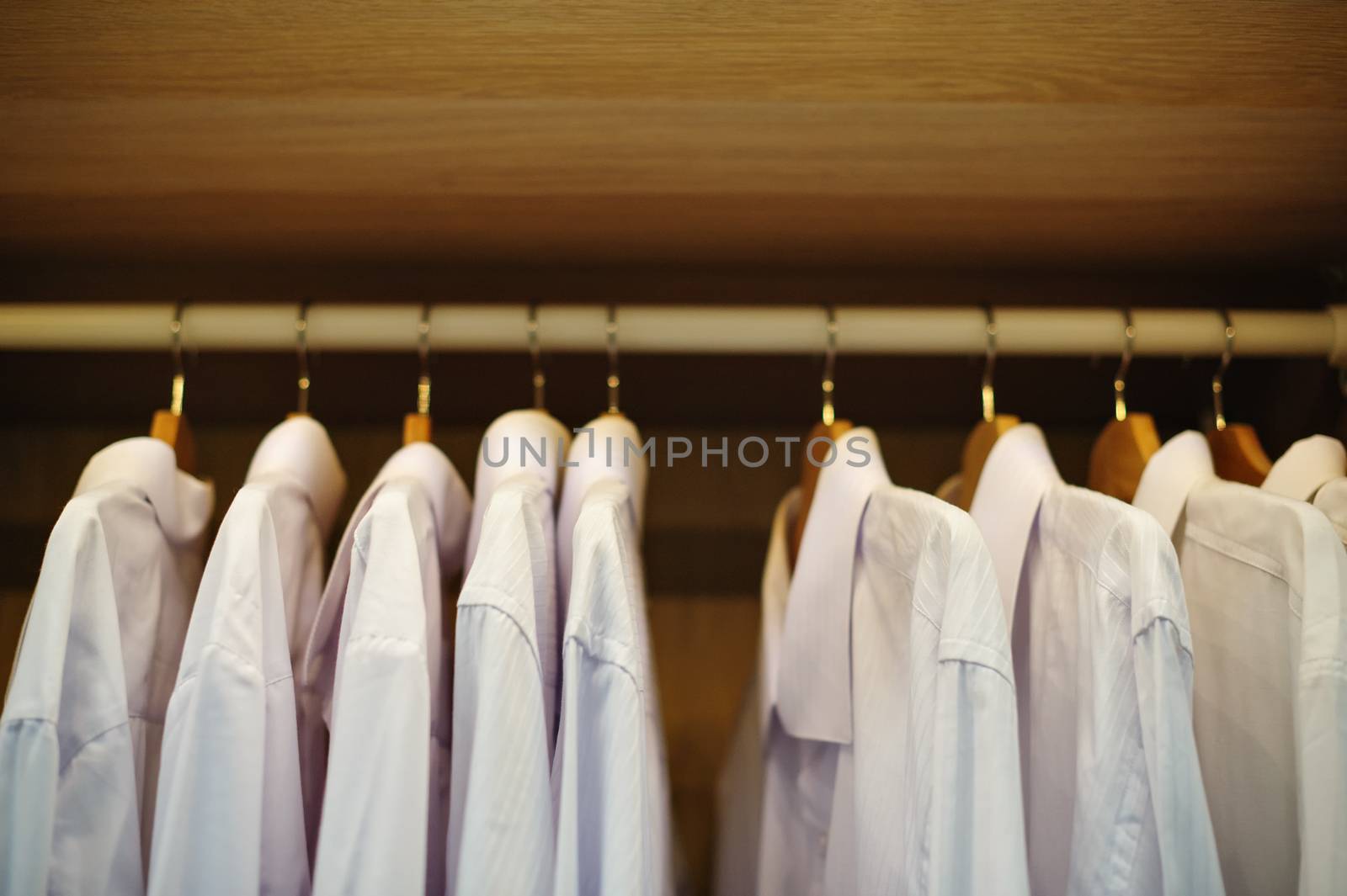 white shirt hanging on a hanger in the closet.