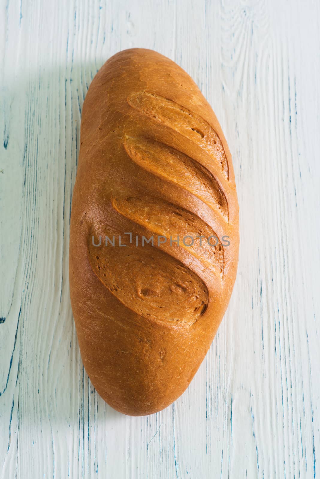 Loaf bread on wooden background by kzen