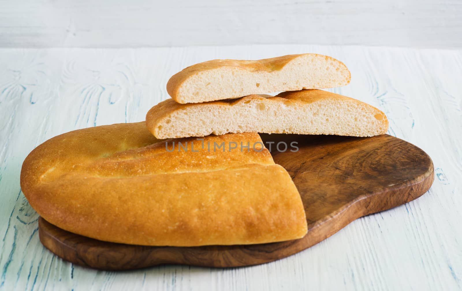 Sliced wheat pita bread on a light wood table by kzen