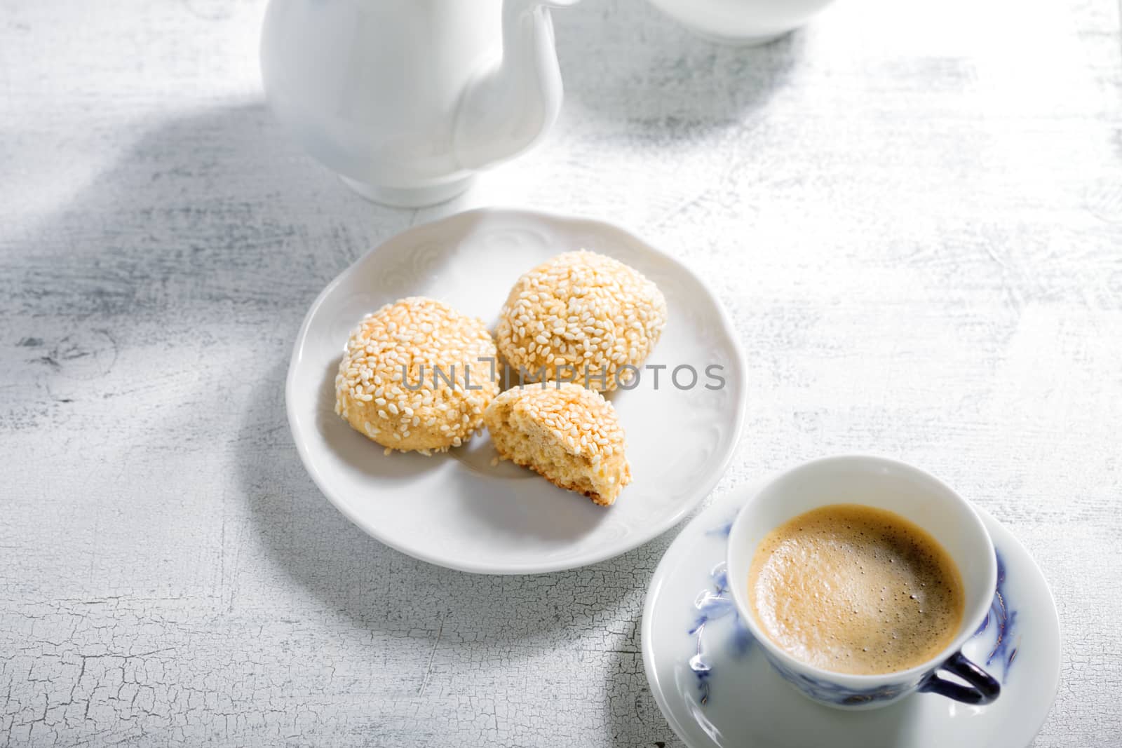 Almond cookies and coffee on white table.