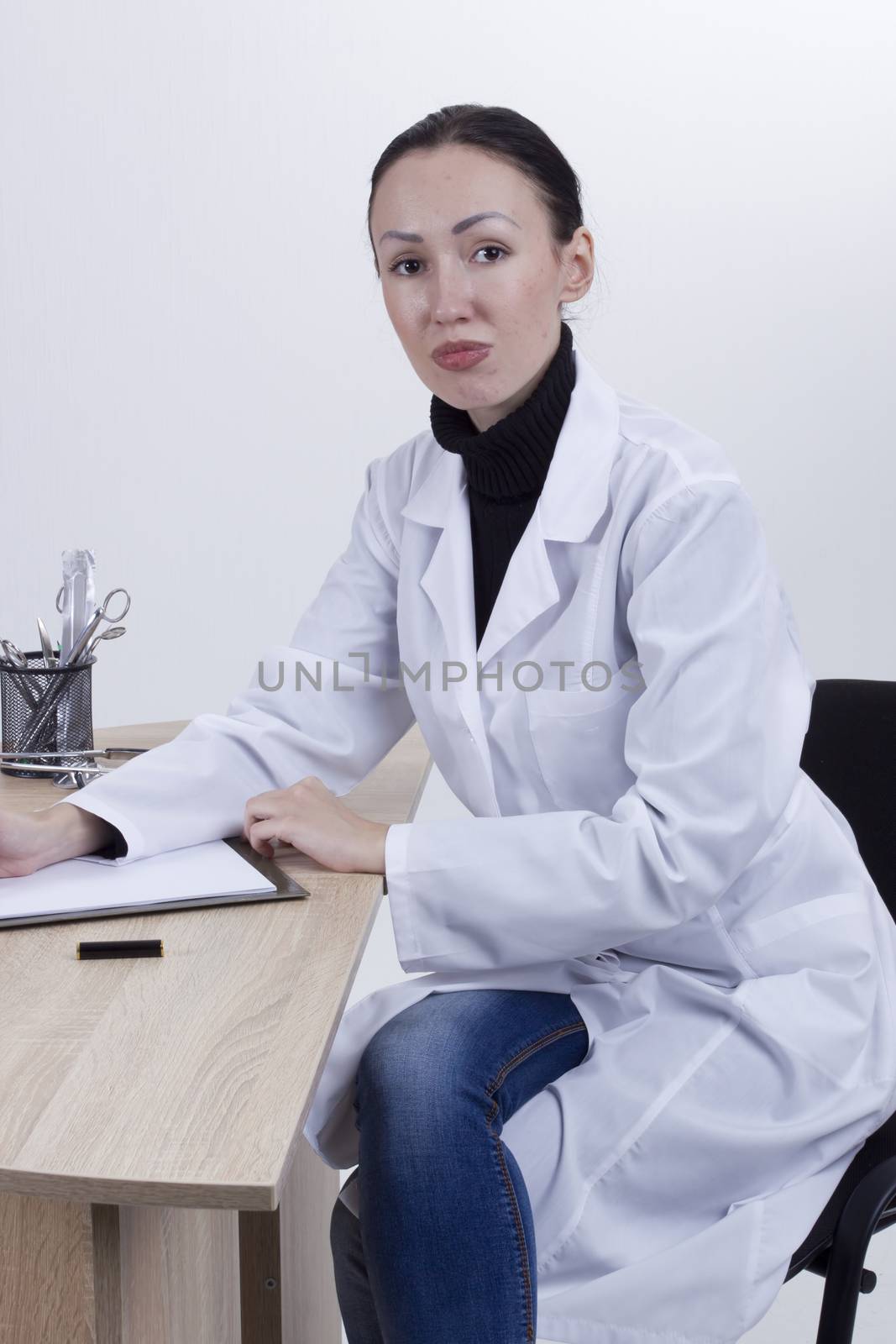 Young female doctor working at his desk