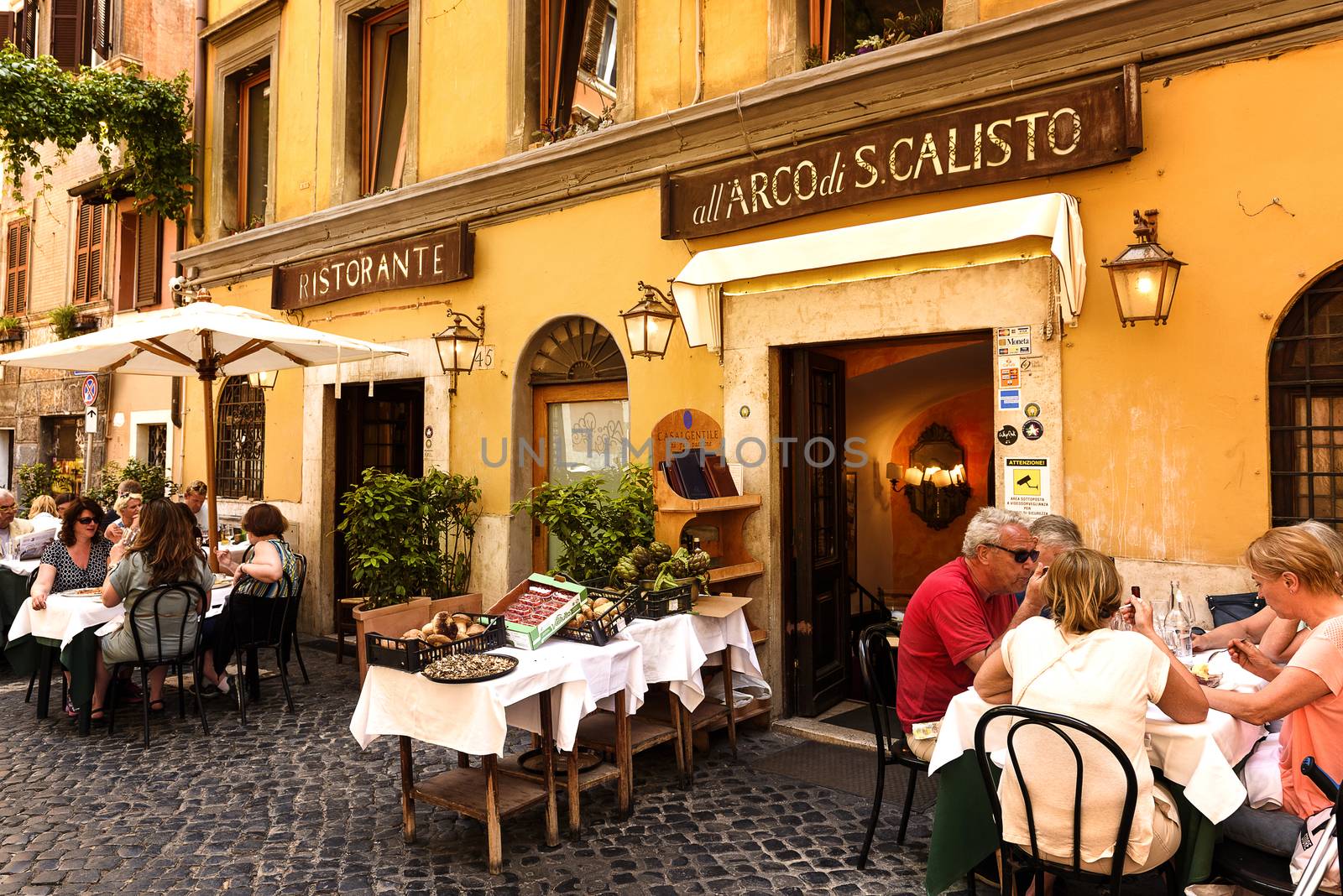 Rome, Italy - May 27, 2016: Unidentified people eating traditional italian food in outdoor restaurant in Trastevere district in Rome, Italy.