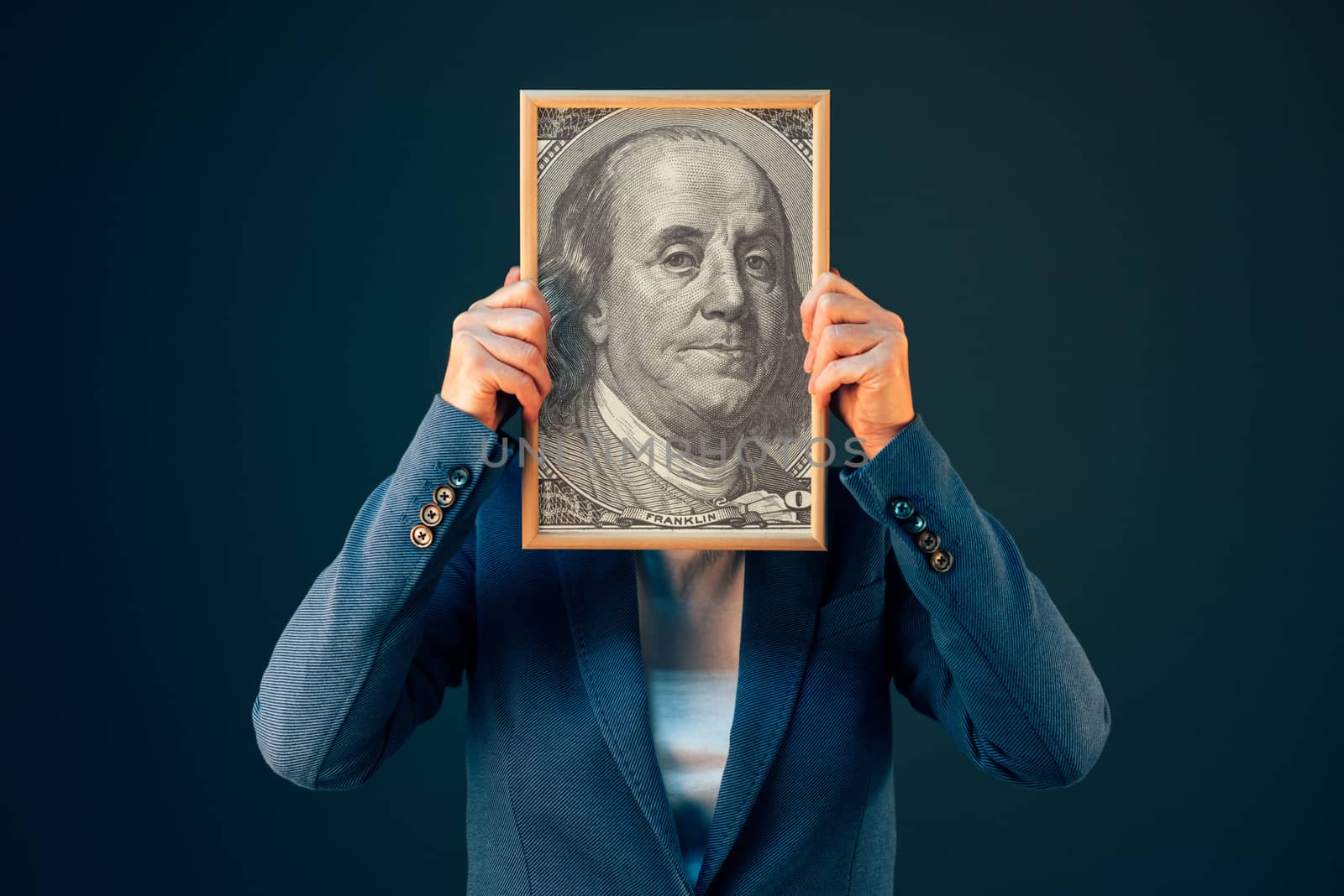 Businesswoman holding Benjamin Franklin 100 USA dollar portrait by stevanovicigor