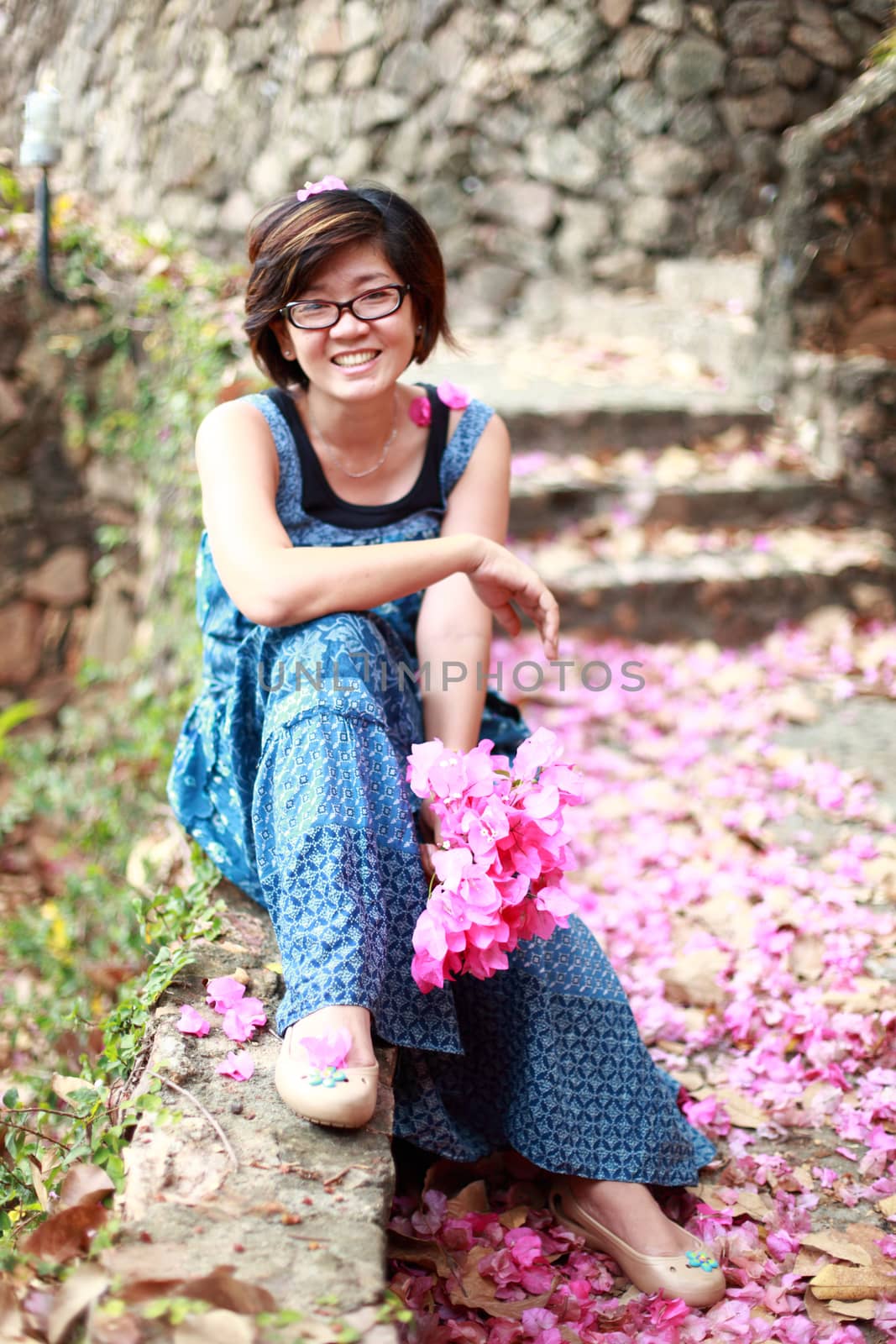 asian woman with pink flower bouquet in her hand smilling to cam by khunaspix