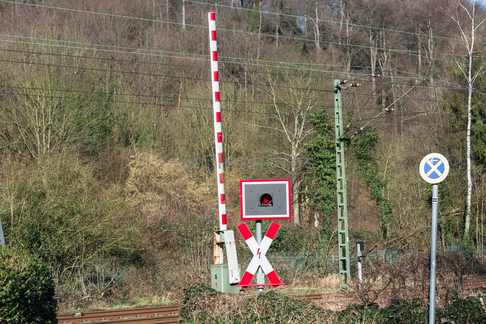 Open railway barrier at a railway crossing in Germany.
