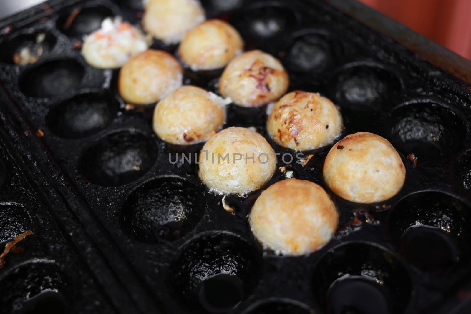 takoyaki, octopus balls, japanese food  on cooking hot pan