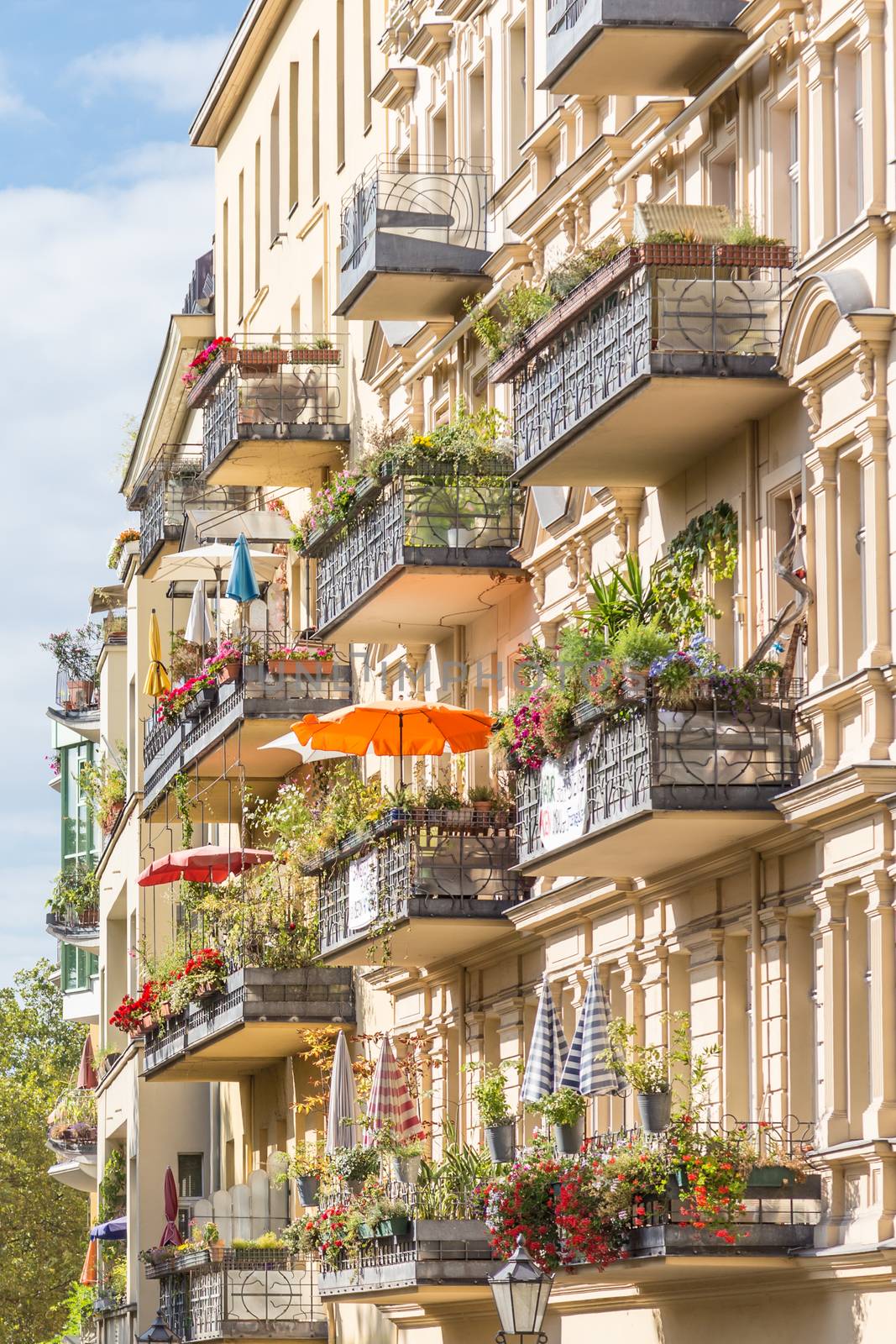 Traditional European residential house with balconys with colorful flowers and flowerpots. Kreuzberg neighborhood, Berlin, Germany,