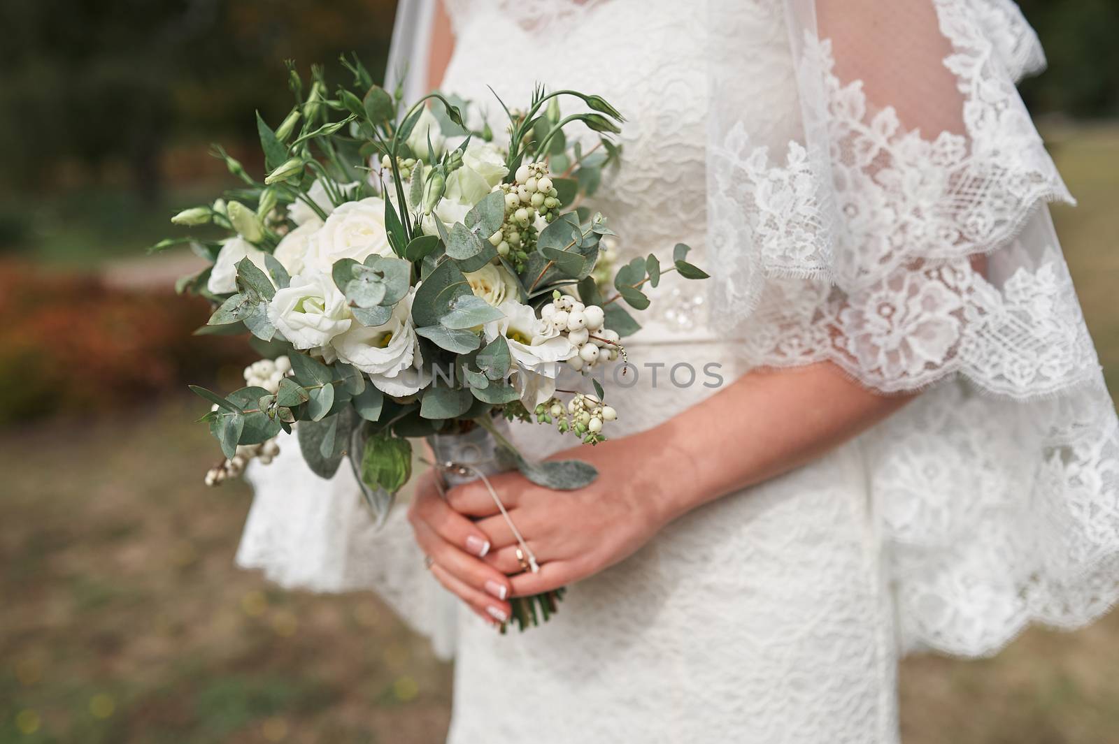 bride holding a bouquet of white roses in wedding day