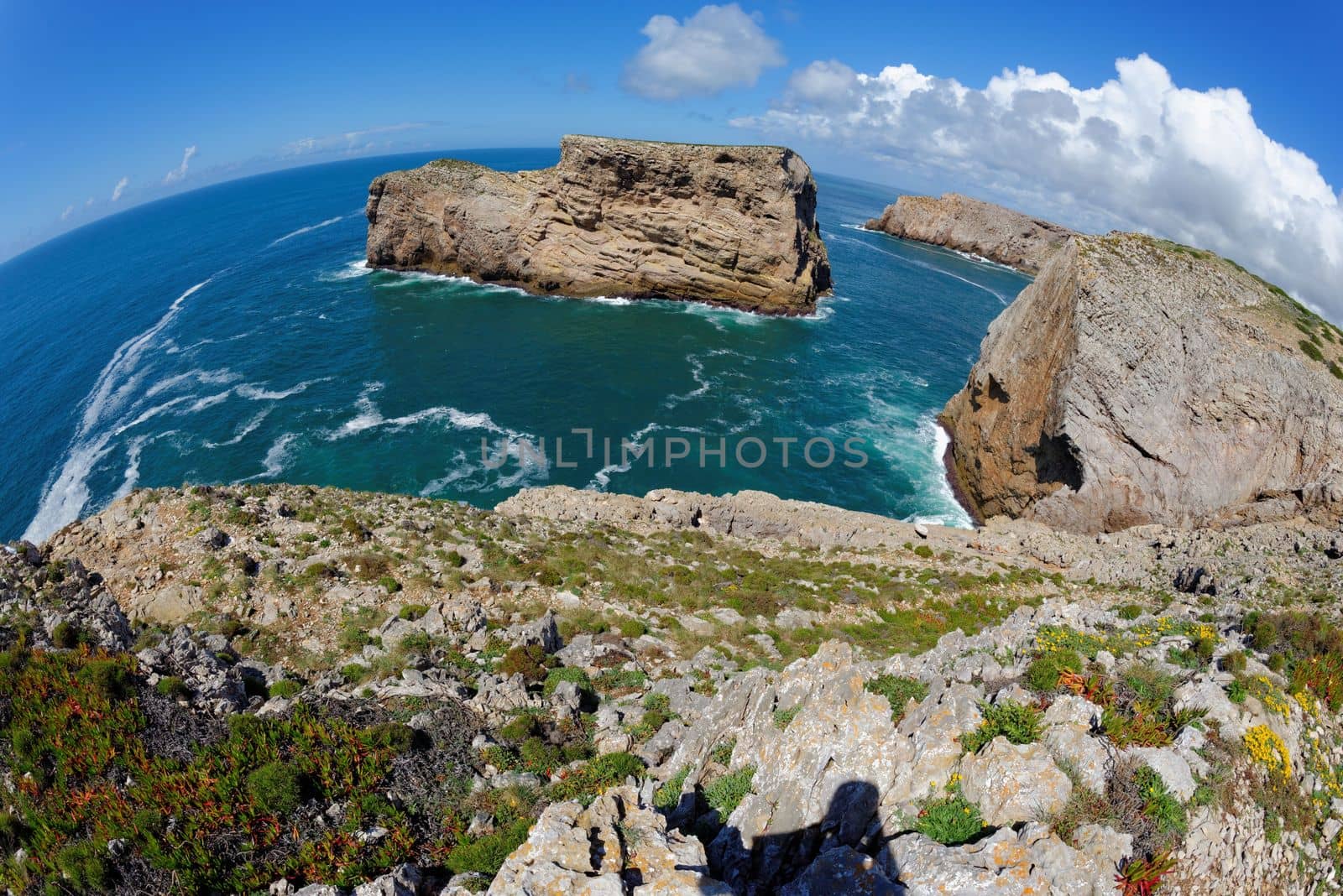 Fisheye view of scenic rocks in the ocean near Cabo de Sao Vicente Cape in the Algarve, Portugal