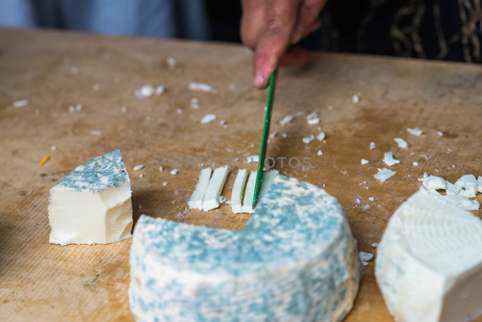 a pieces of cheese with blue mold is cut with a knife