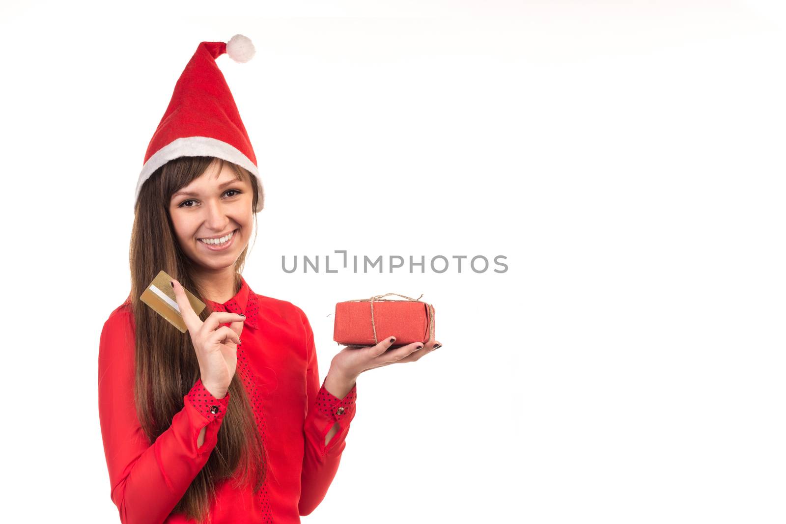 Young long-haired woman in red christmas cap with gold credit card and red gift box