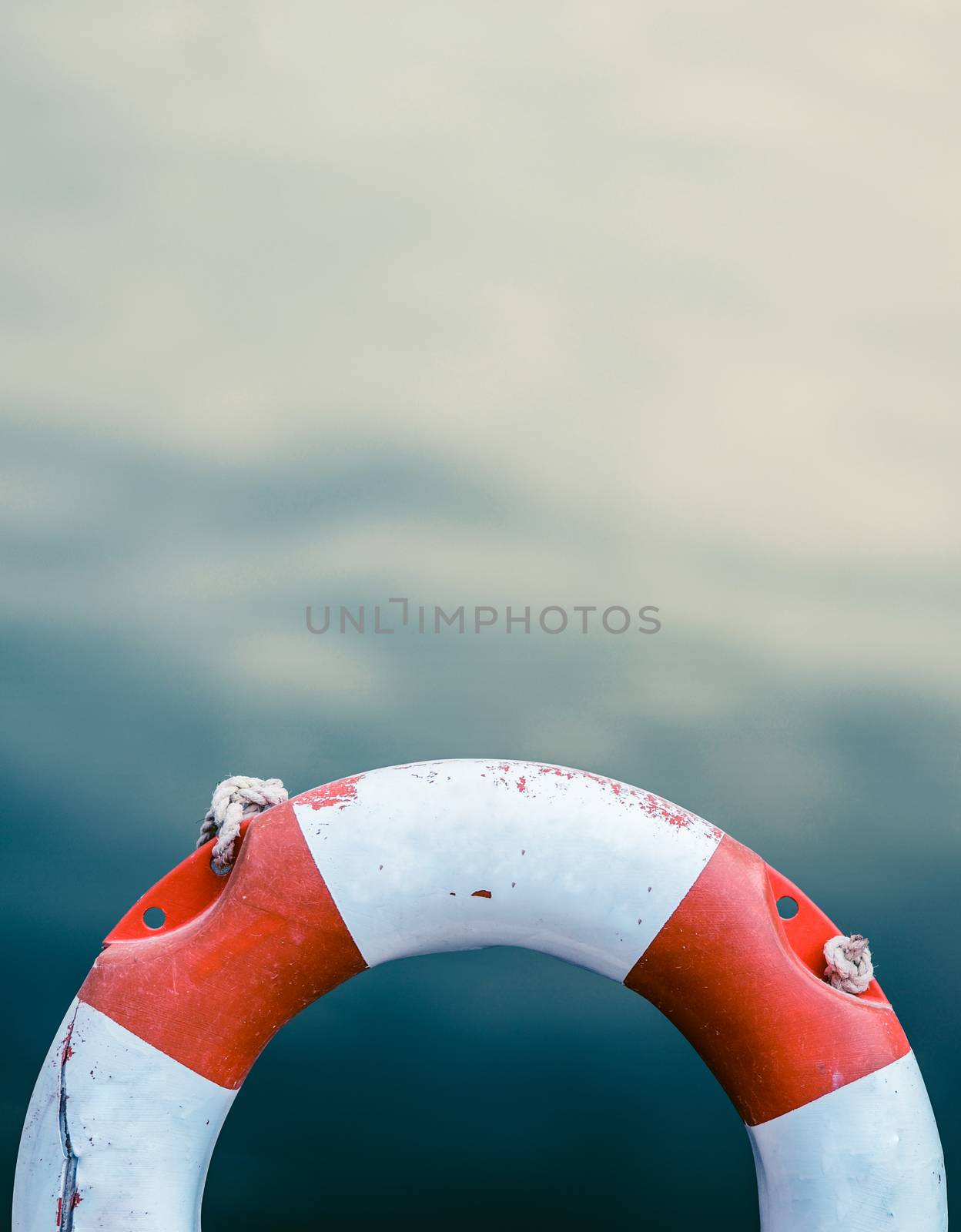 Grungy Lifebuoy Against A Calm Ocean Water Background With Copy Space