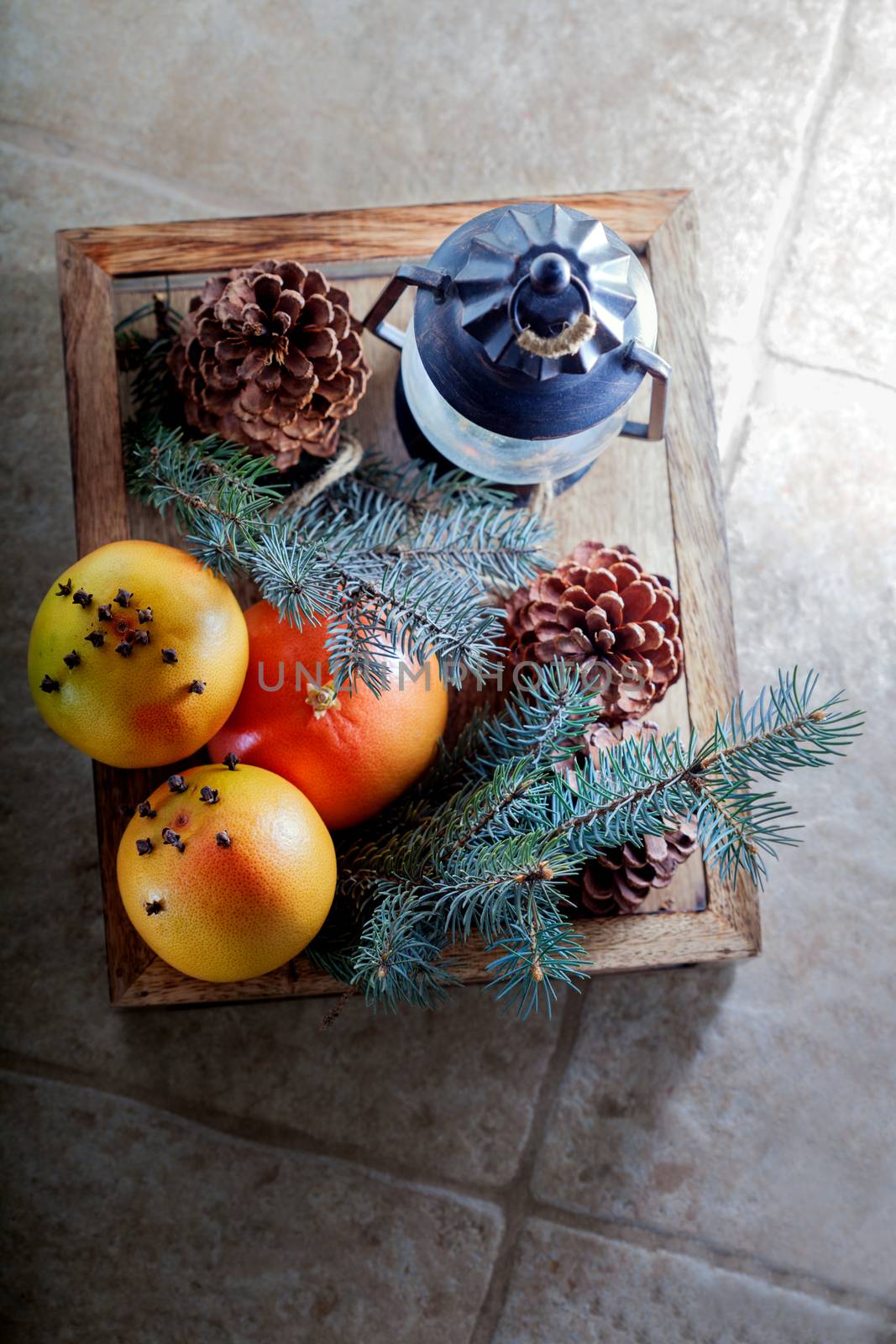 Christmas oranges in wooden box on a stone surface