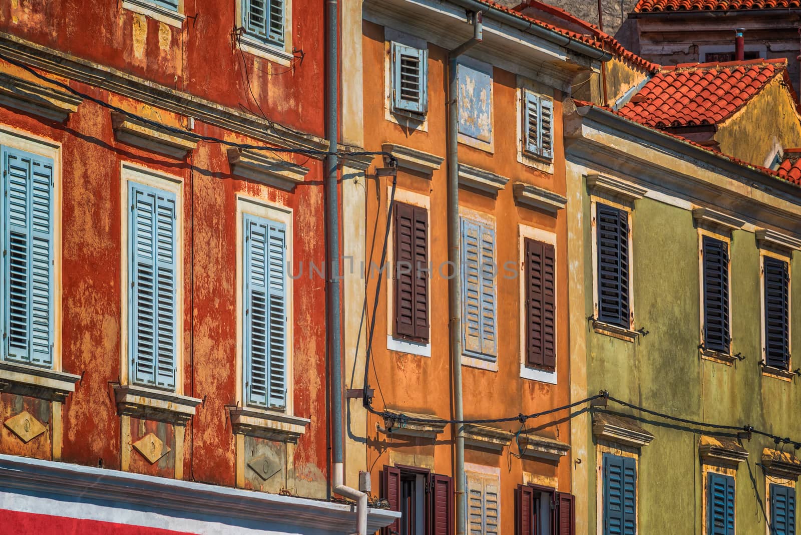 Weathered colorful mediterranean town building facades by stevanovicigor