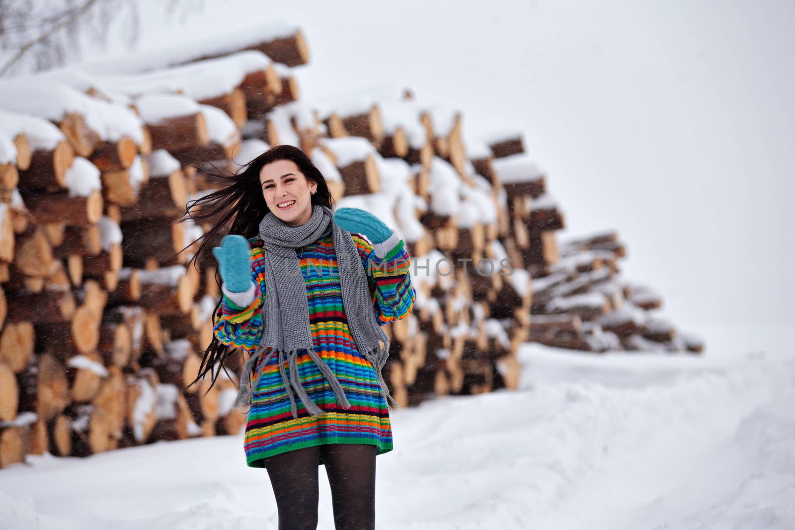 Beautiful young woman walking in winter outdoors. Wood logging