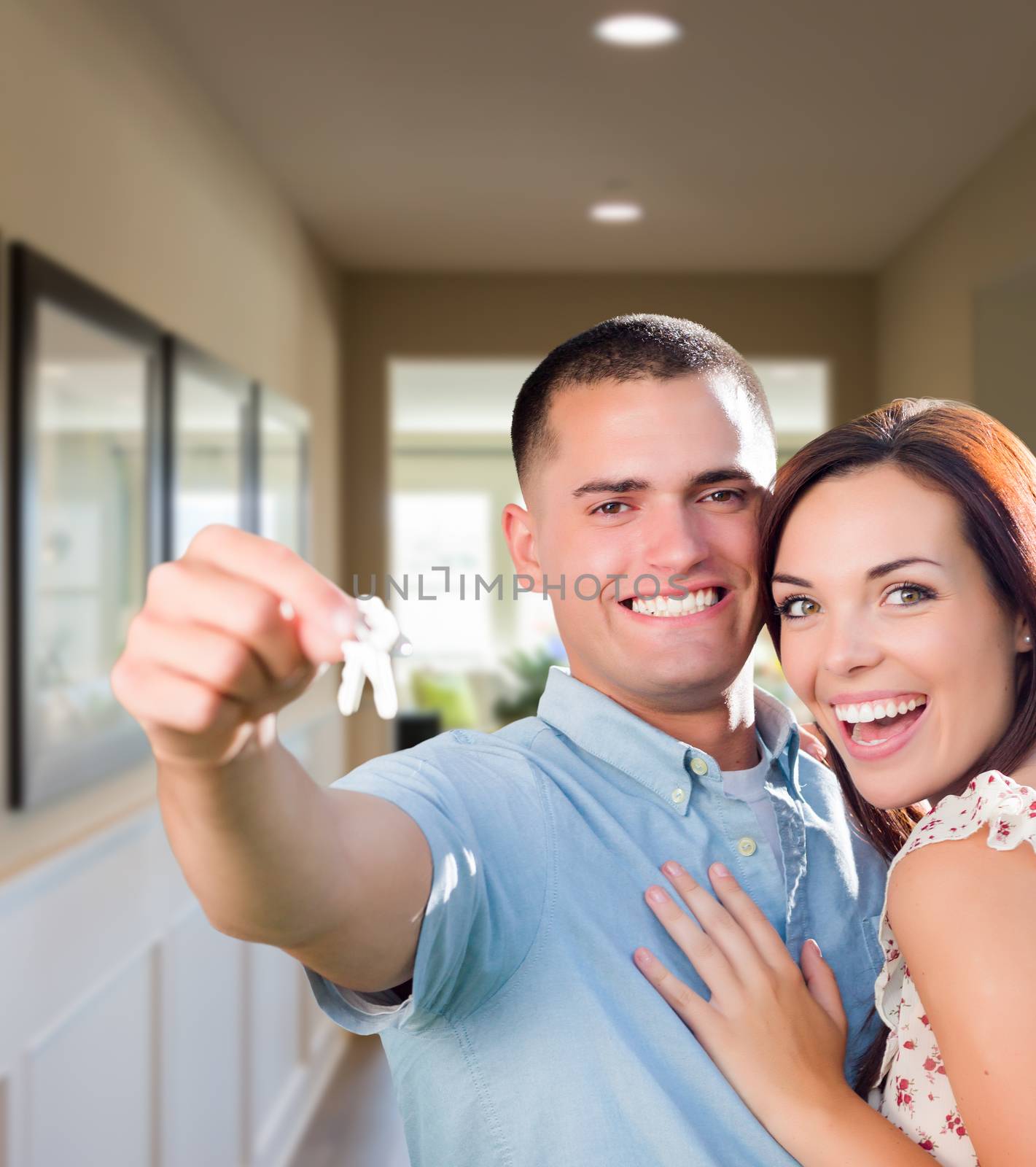 Happy Military Couple with House Keys Inside Hallway of New Home.