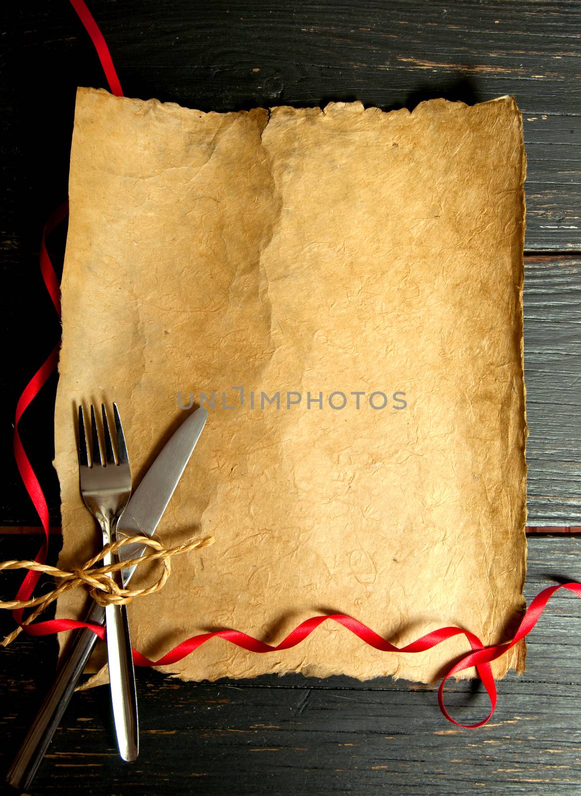 Fork and knife on an empty paper scroll with space 