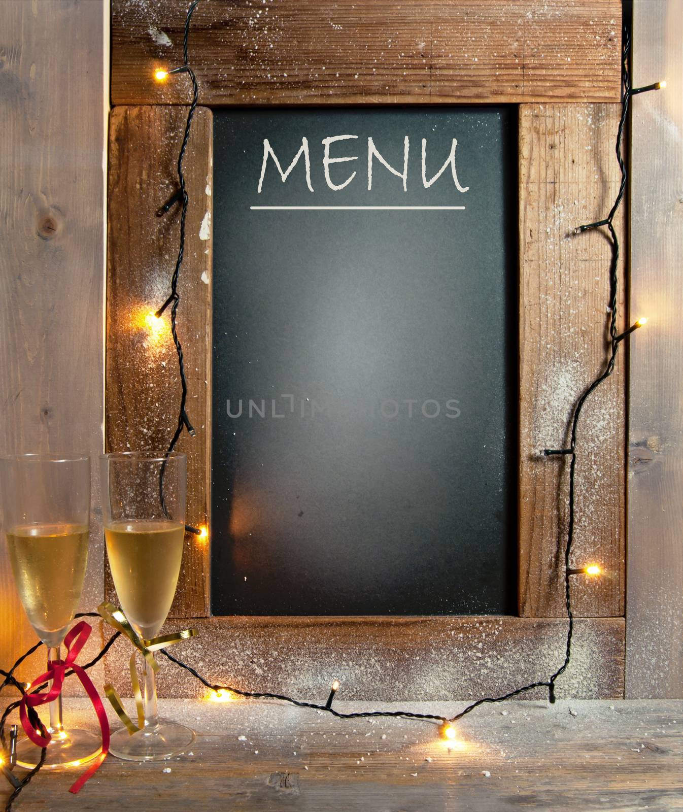Champagne glasses next to menu board with space