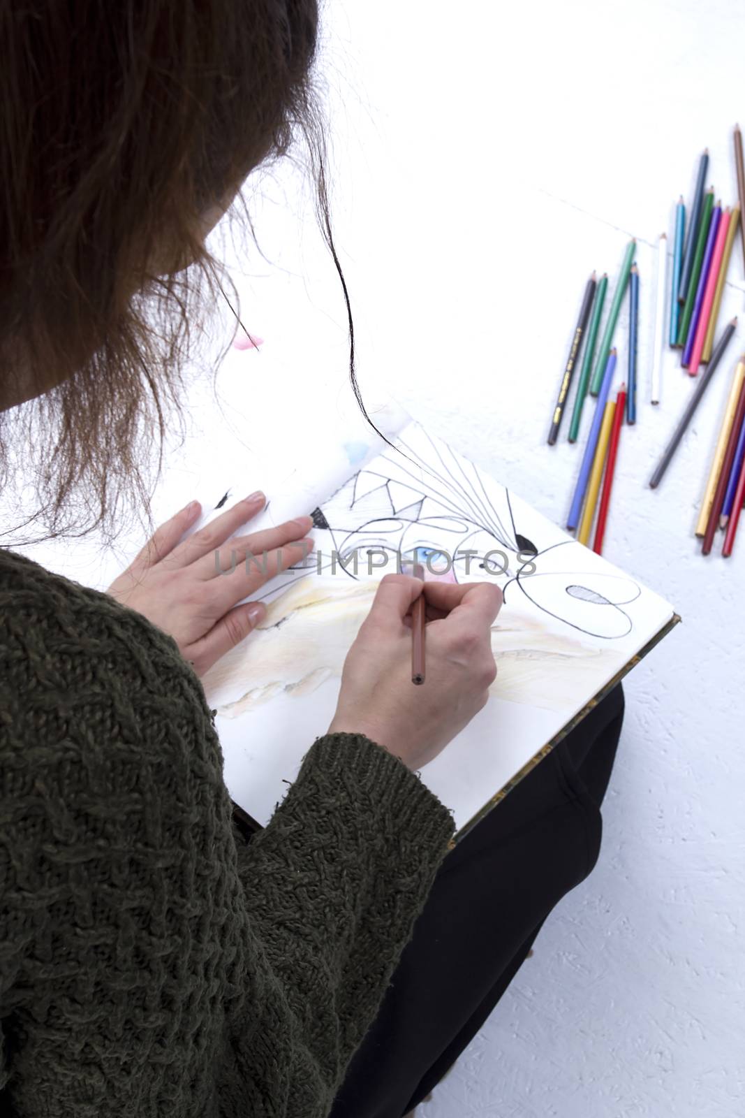 Young girl artist drawing pencils on white background