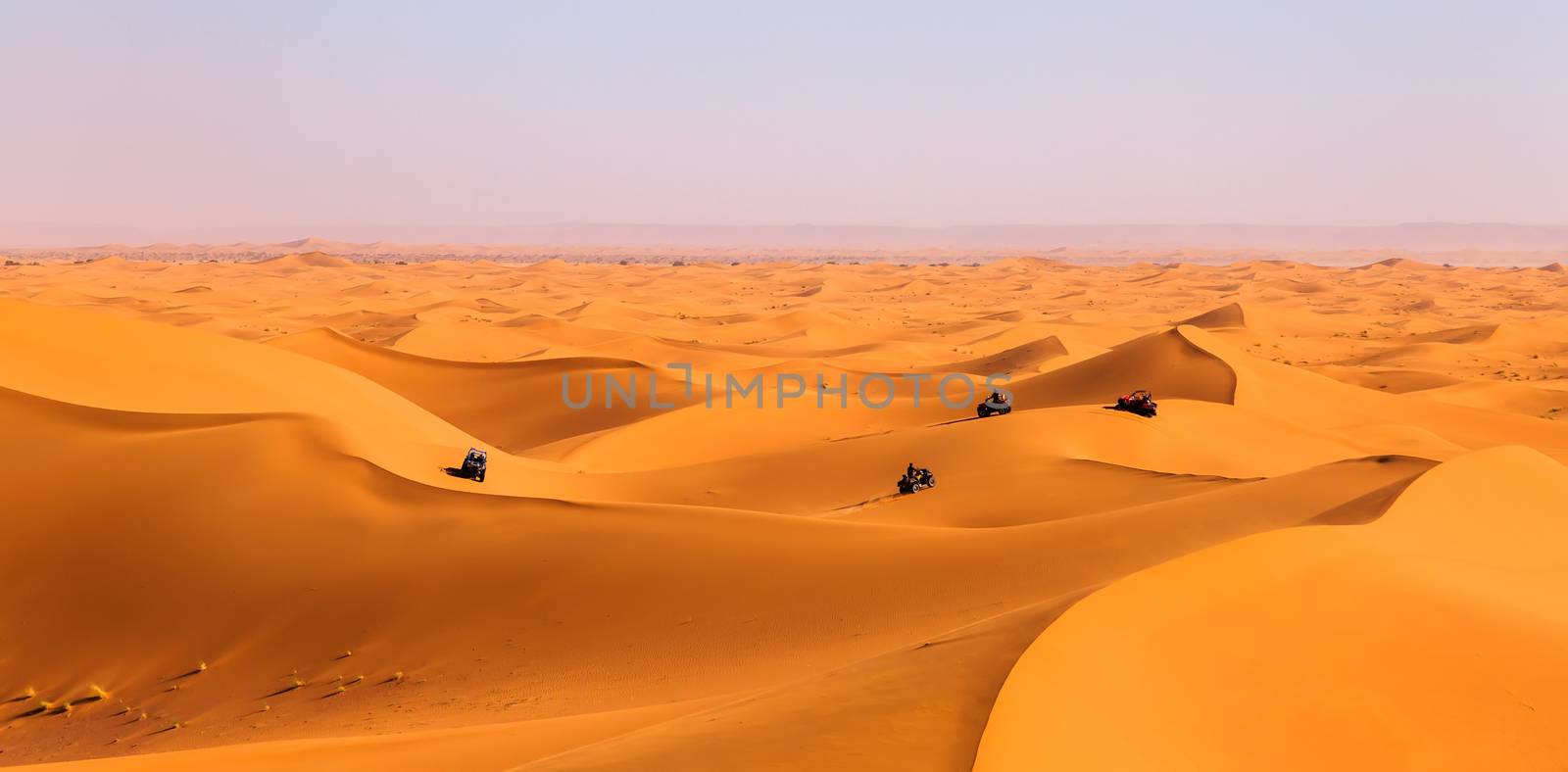 Tourists driving quads and all-terrain vehicles in sahara dunes by pixinoo