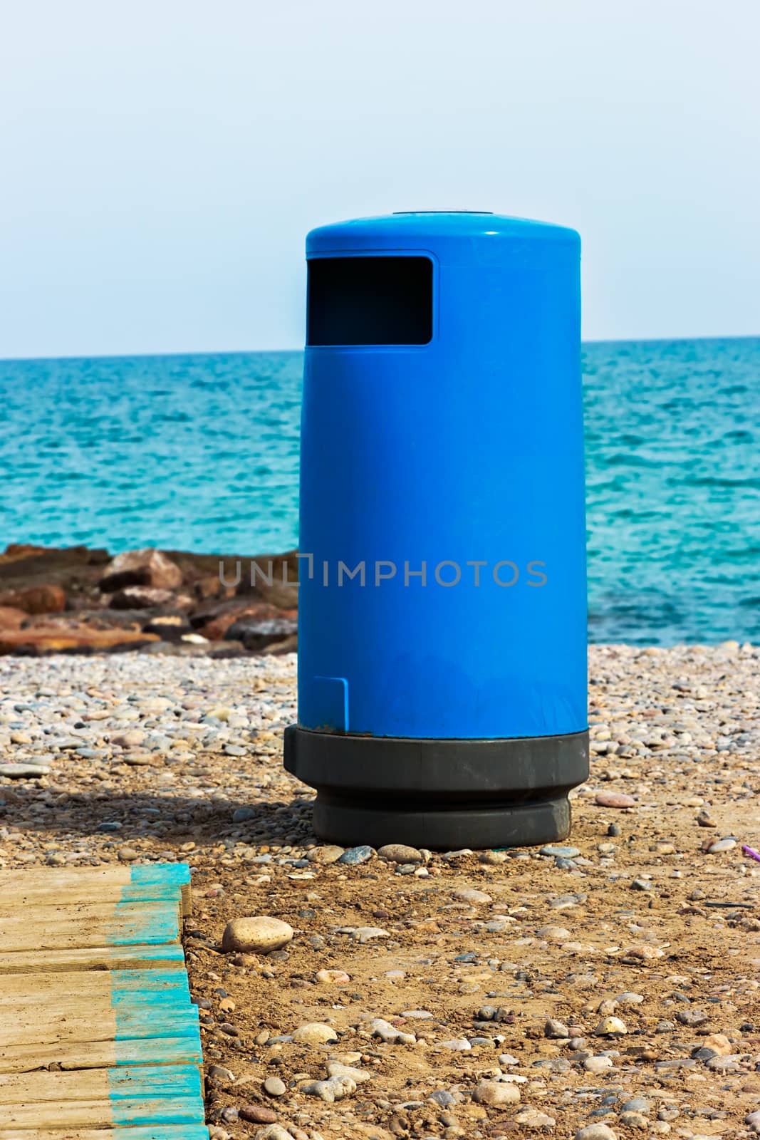 Blue beach trash with walkway. Vertical image.