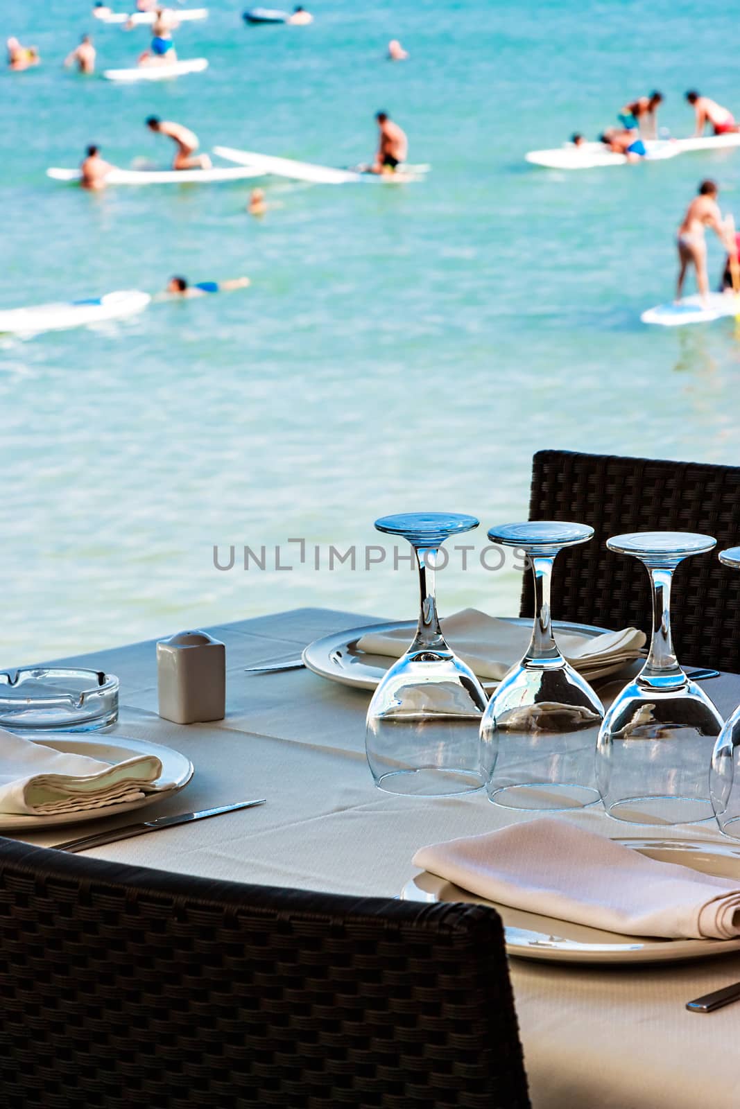 Restaurant on the seashore with the table set. Vertical image.