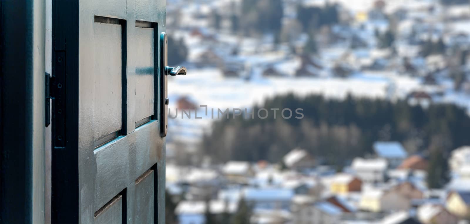 Opened door concept to beautiful and imaginary snowy village landscape