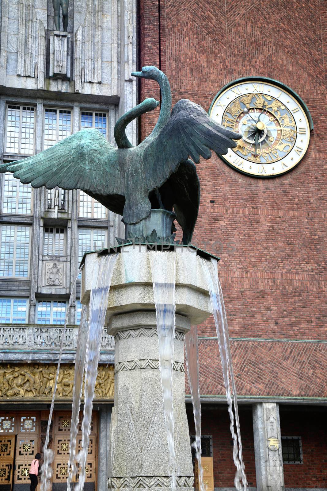 Main entrance of the Oslo City Hall with fountain of City Hall and clock in Oslo, Norway 
