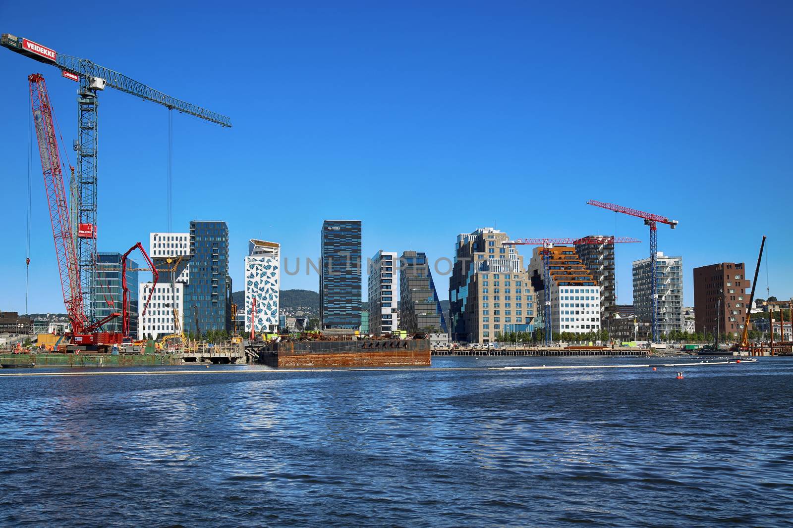 OSLO, NORWAY – AUGUST 17, 2016: A construction site of Bjorvika under construction in progress with a heavy vehicle and cranes in Oslo, Norway on August 17,2016.